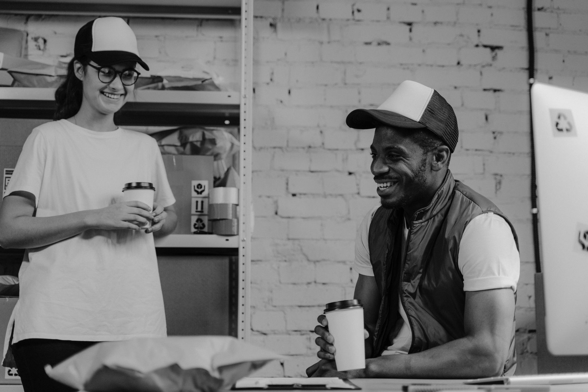 Two coworkers enjoying a coffee break in a relaxed office setting, fostering team bonding.