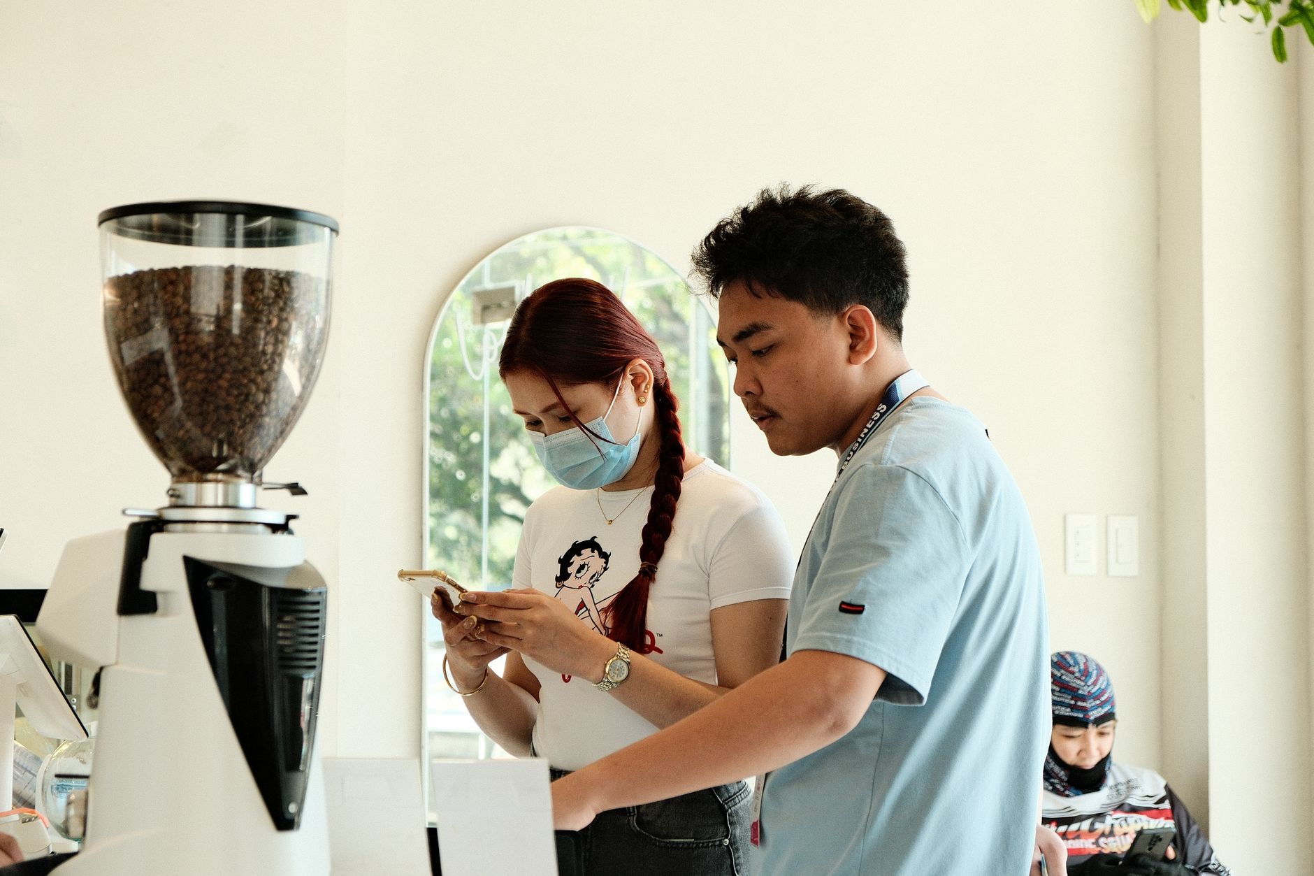 Barista takes order in a bright cafe setting, capturing the vibrant coffee shop atmosphere.
