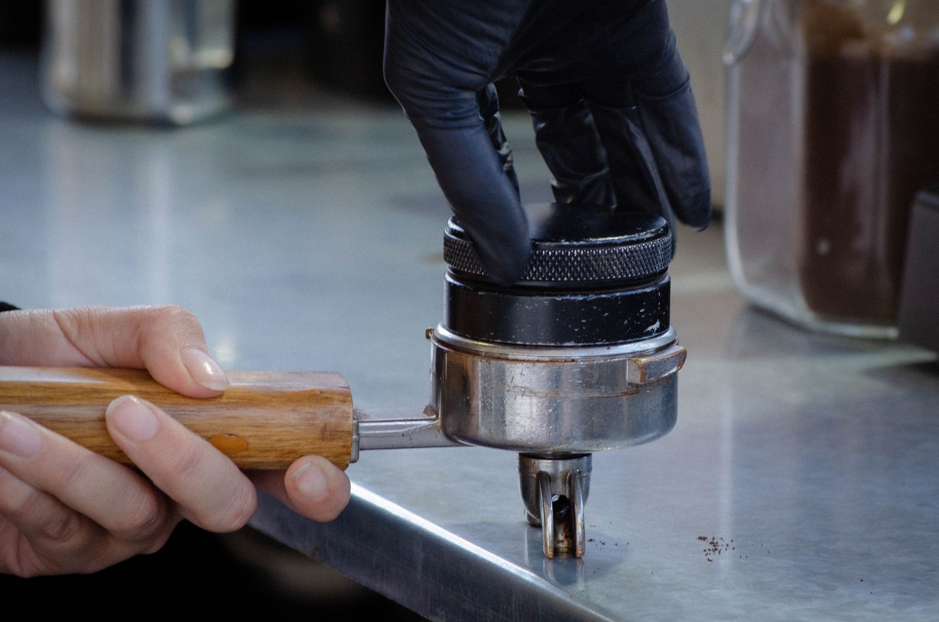 Barista tamping coffee grounds in a Tepic café. Hands focusing on brewing process.