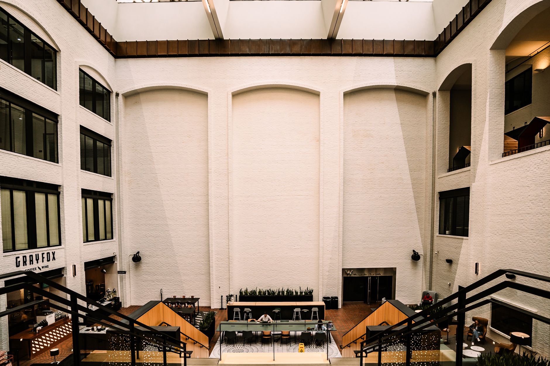 Spacious indoor atrium with modern design, cafeteria seating, and natural light.