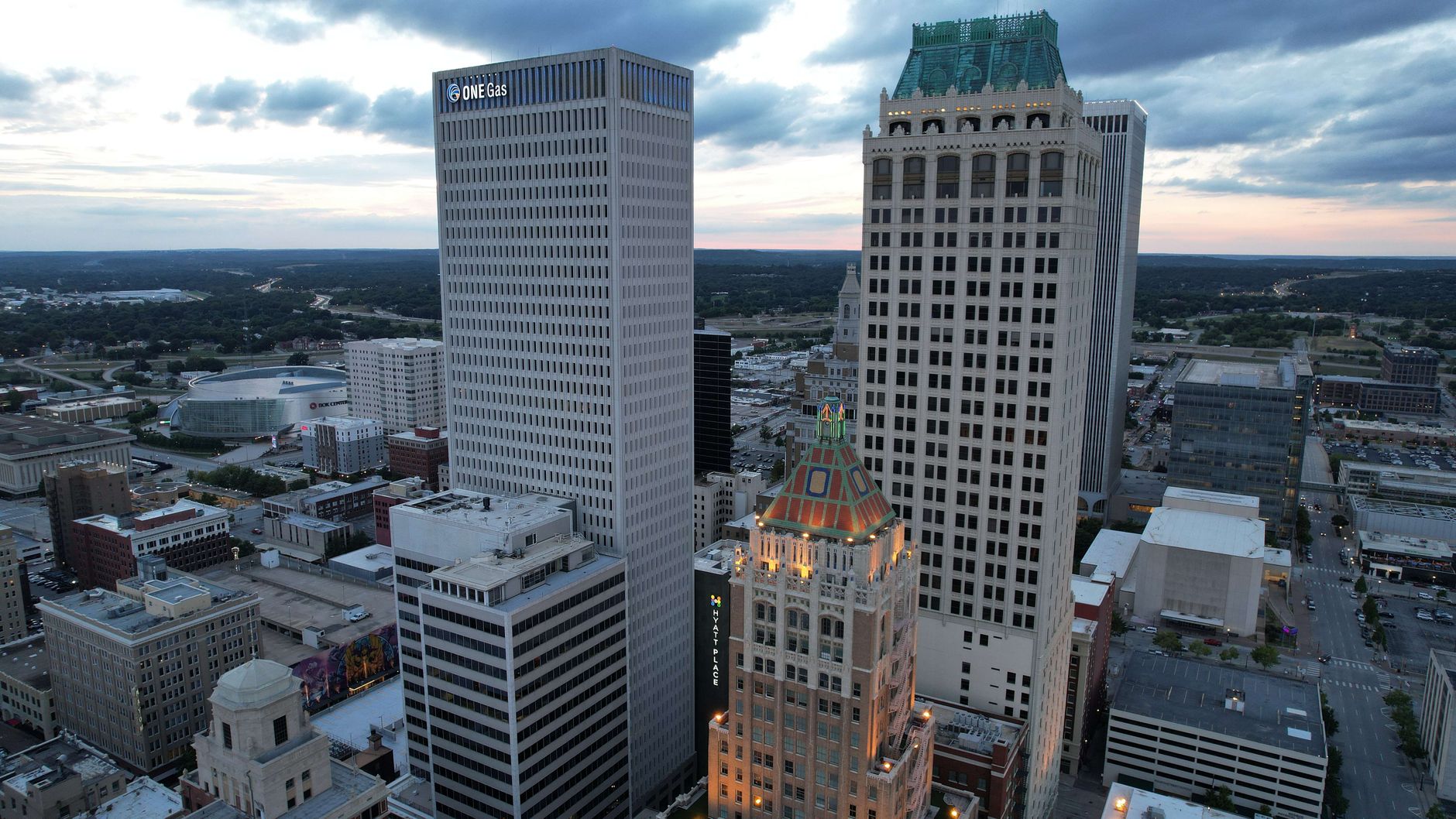 Aerial view of Tulsa cityscape with prominent ONEOK Building at twilight.