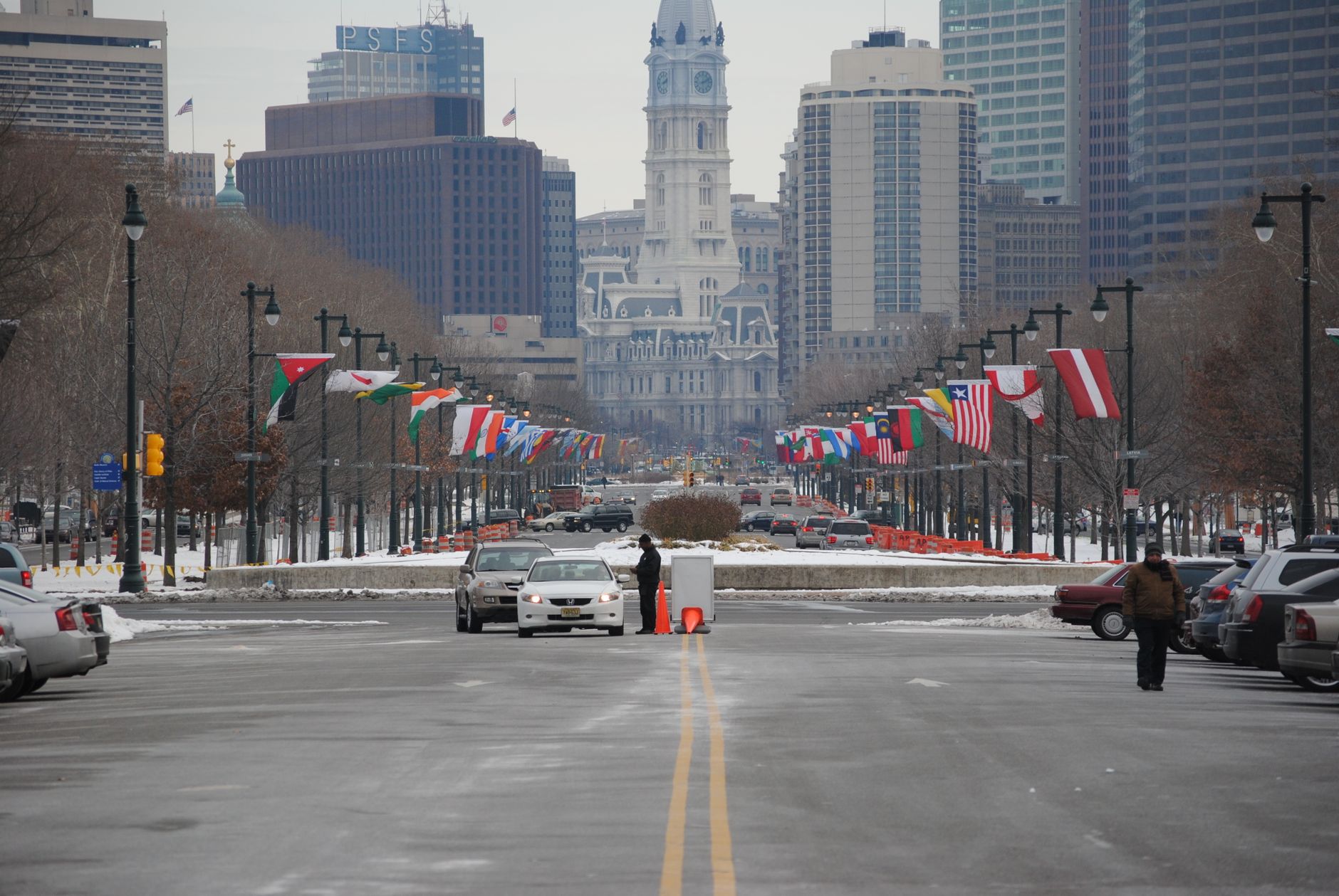 View of Philadelphia City Hall and flags along snowy street. Iconic cityscape in winter.
