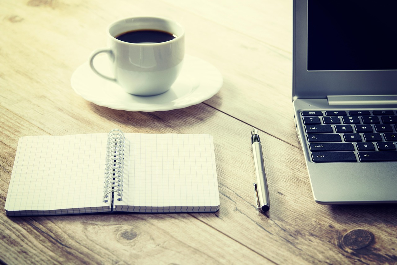 coffee, computer, cup, desk, drink, laptop, notebook, pen, table, wooden table, coffee cup, workspace, work from home