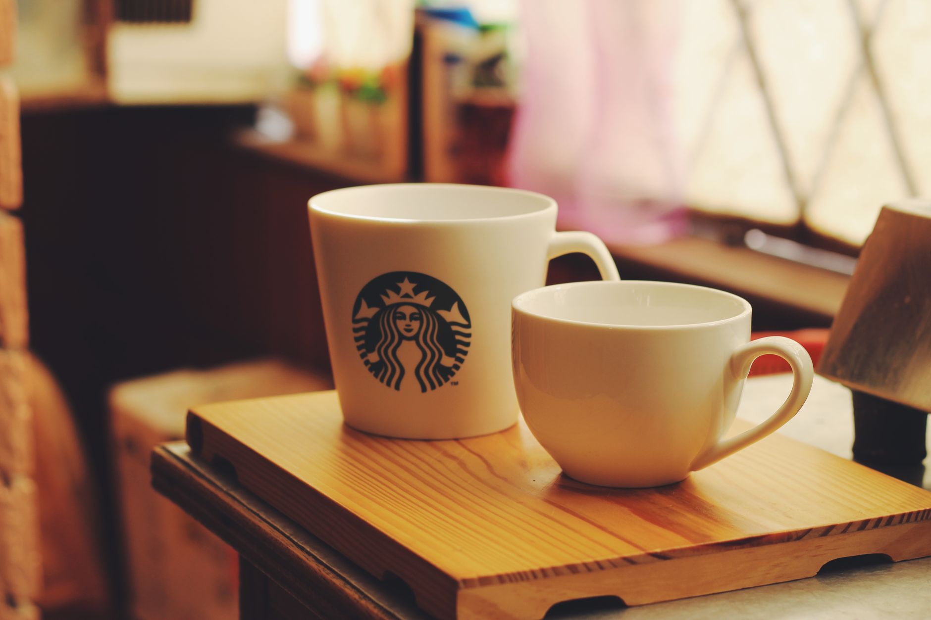 A cozy scene featuring two ceramic coffee cups on a wooden tray, perfect for a warm morning.