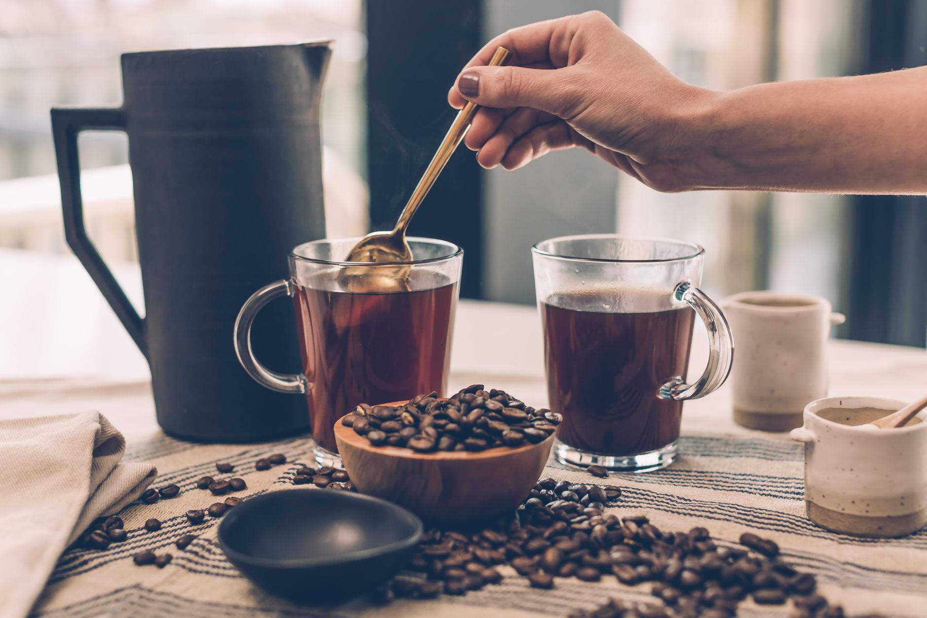 A warm and inviting scene showcasing freshly brewed coffee with beans and utensils.