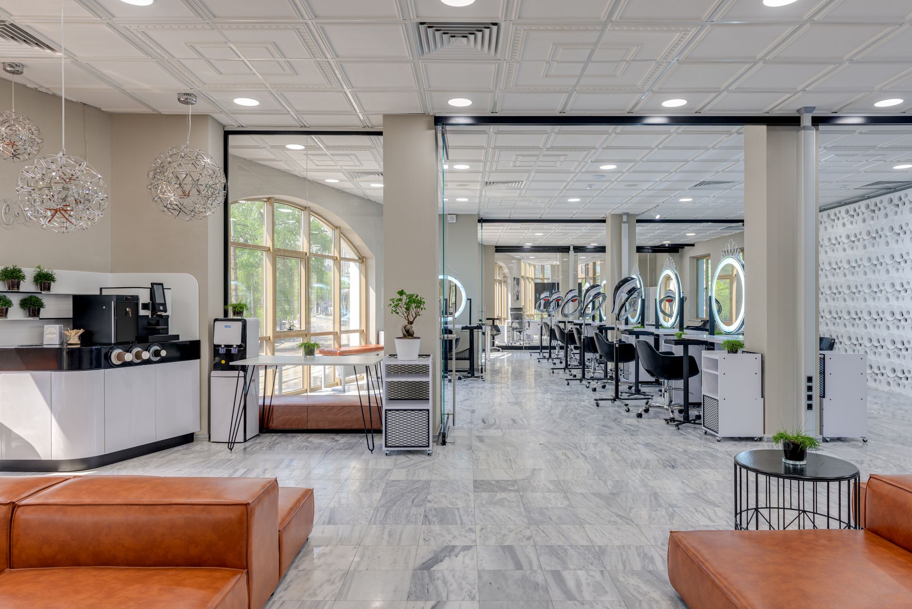 Bright and spacious modern beauty salon with stylish design, featuring a coffee station and makeup stations.