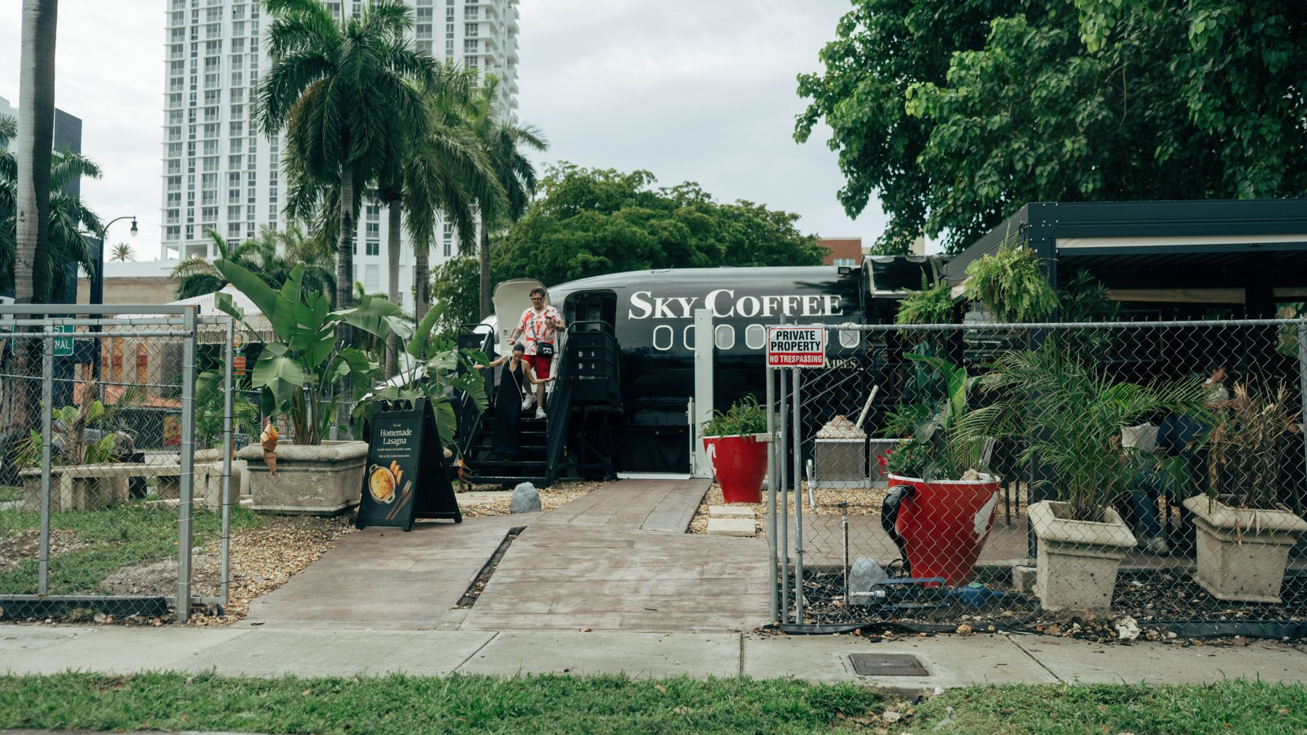 Unique outdoor coffee shop in repurposed airplane setting with lush greenery.