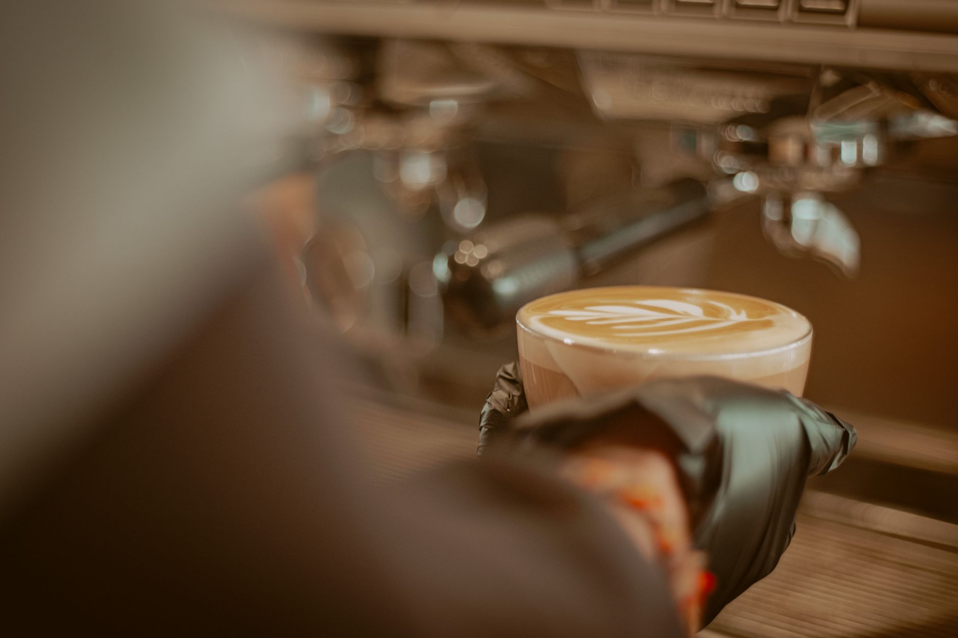 A barista holds a cappuccino with latte art in a Konya cafe, Turkey.