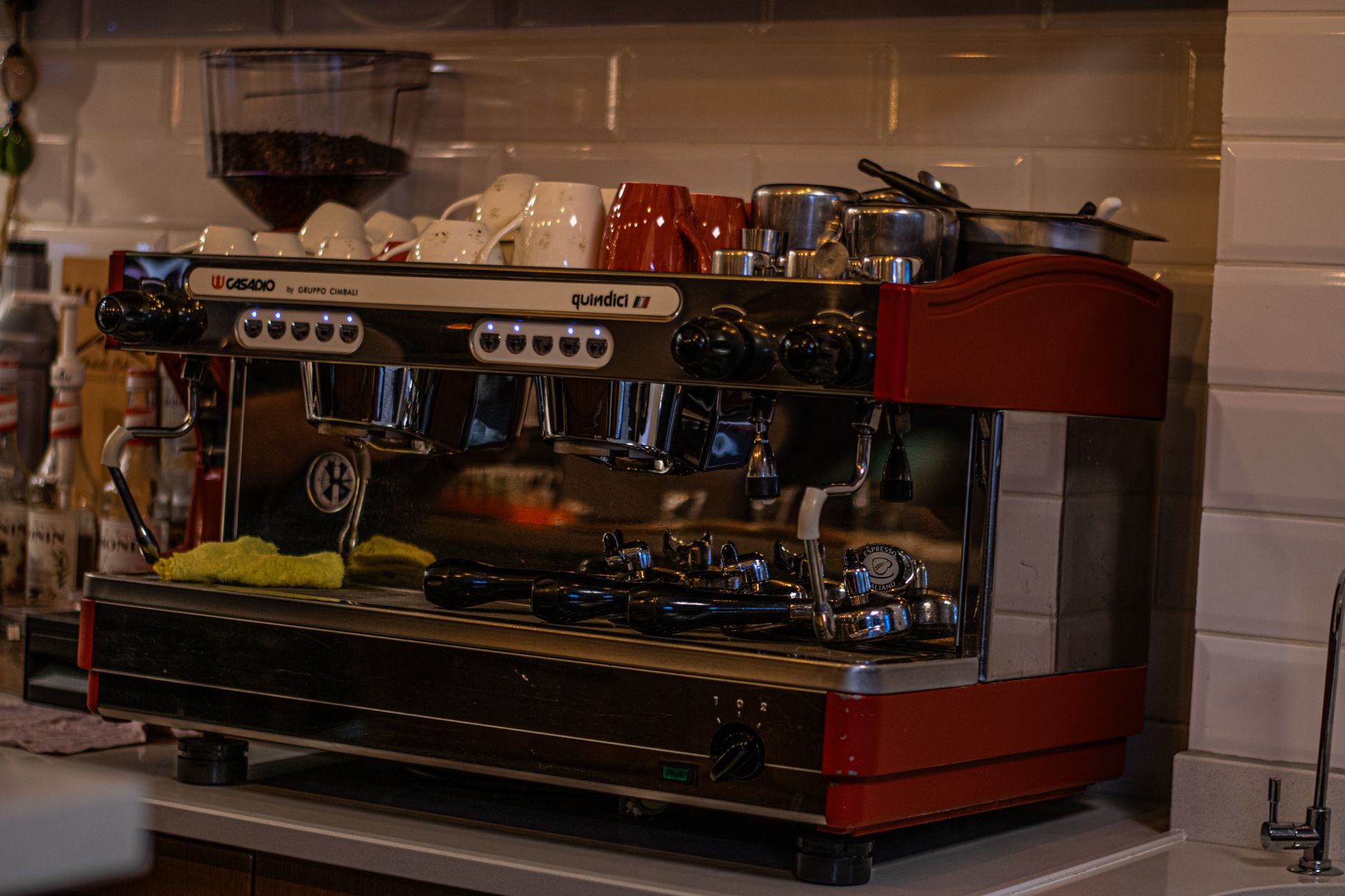 Close-up of a modern espresso machine with cups in a cozy cafe environment.