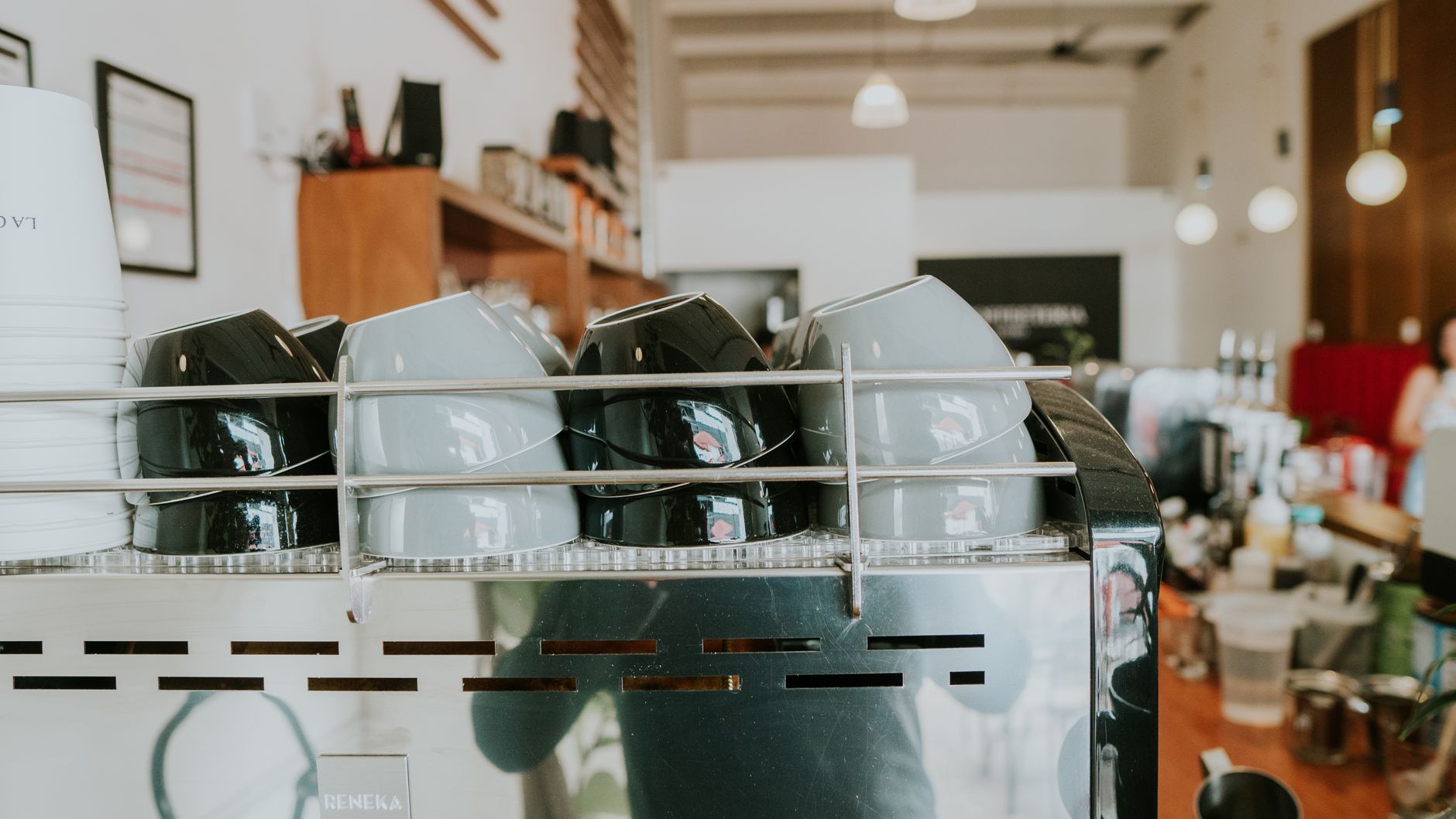 Close-up of stacked ceramic cups on a coffee machine in a trendy café.