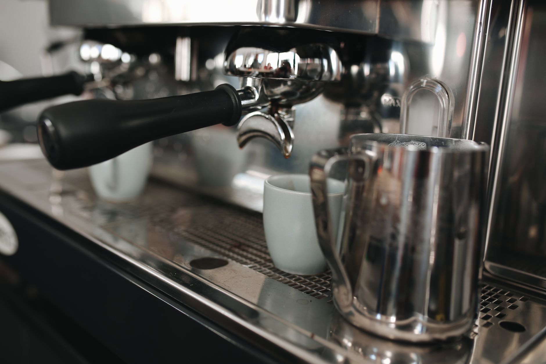 Detailed shot of an espresso machine showcasing portafilter and stainless steel finish.
