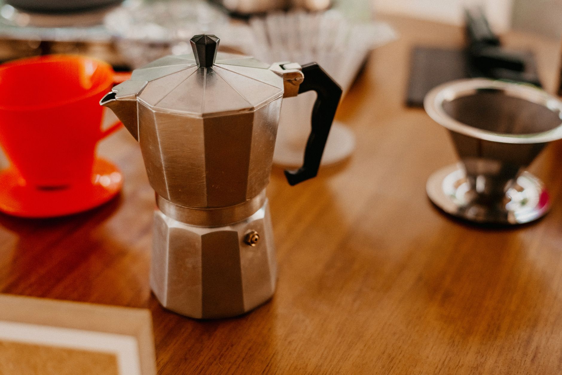 Barista inserting reusable stainless steel filter into commercial drip coffee machine