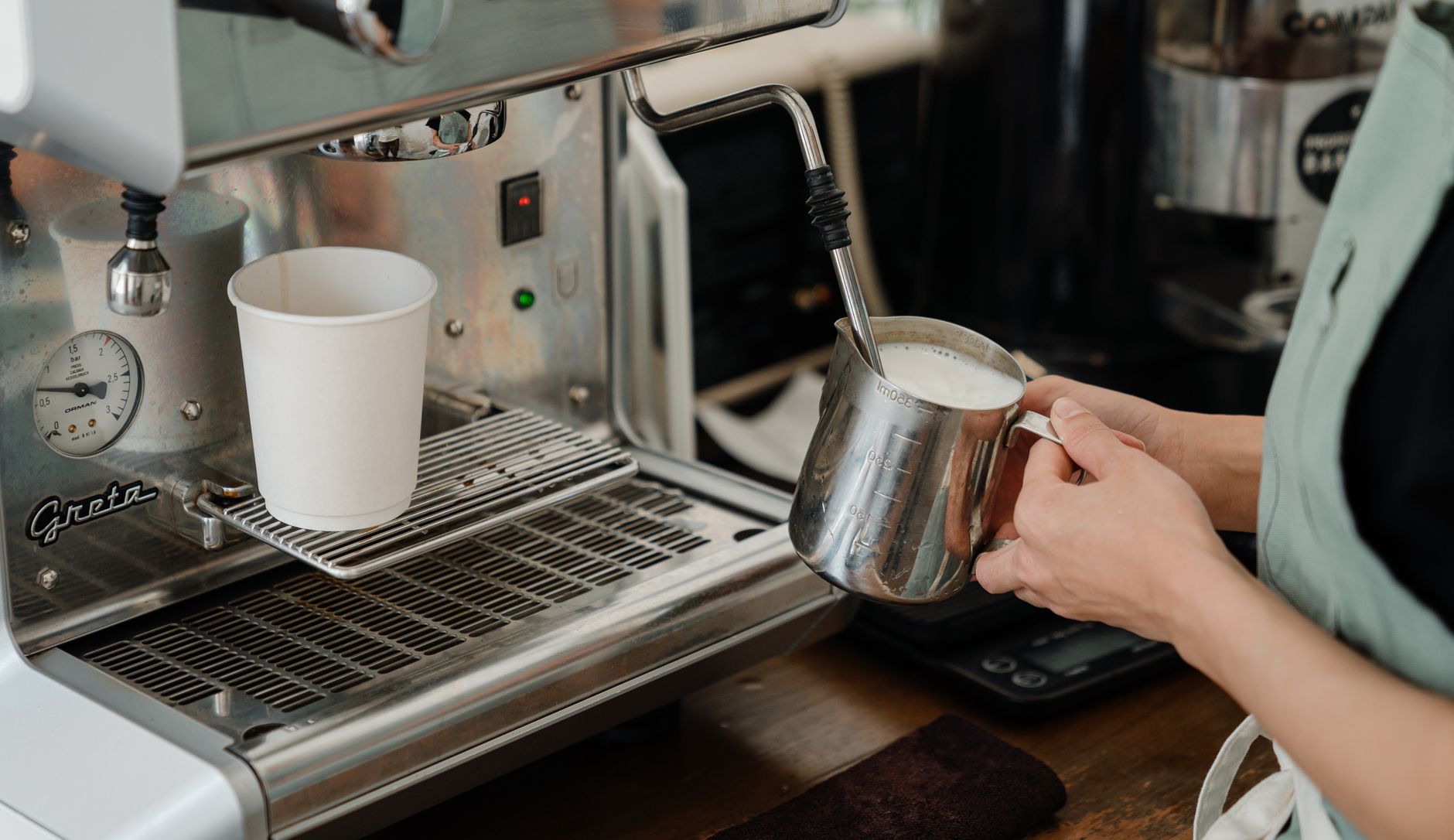 Professional barista preparing espresso in restaurant setting