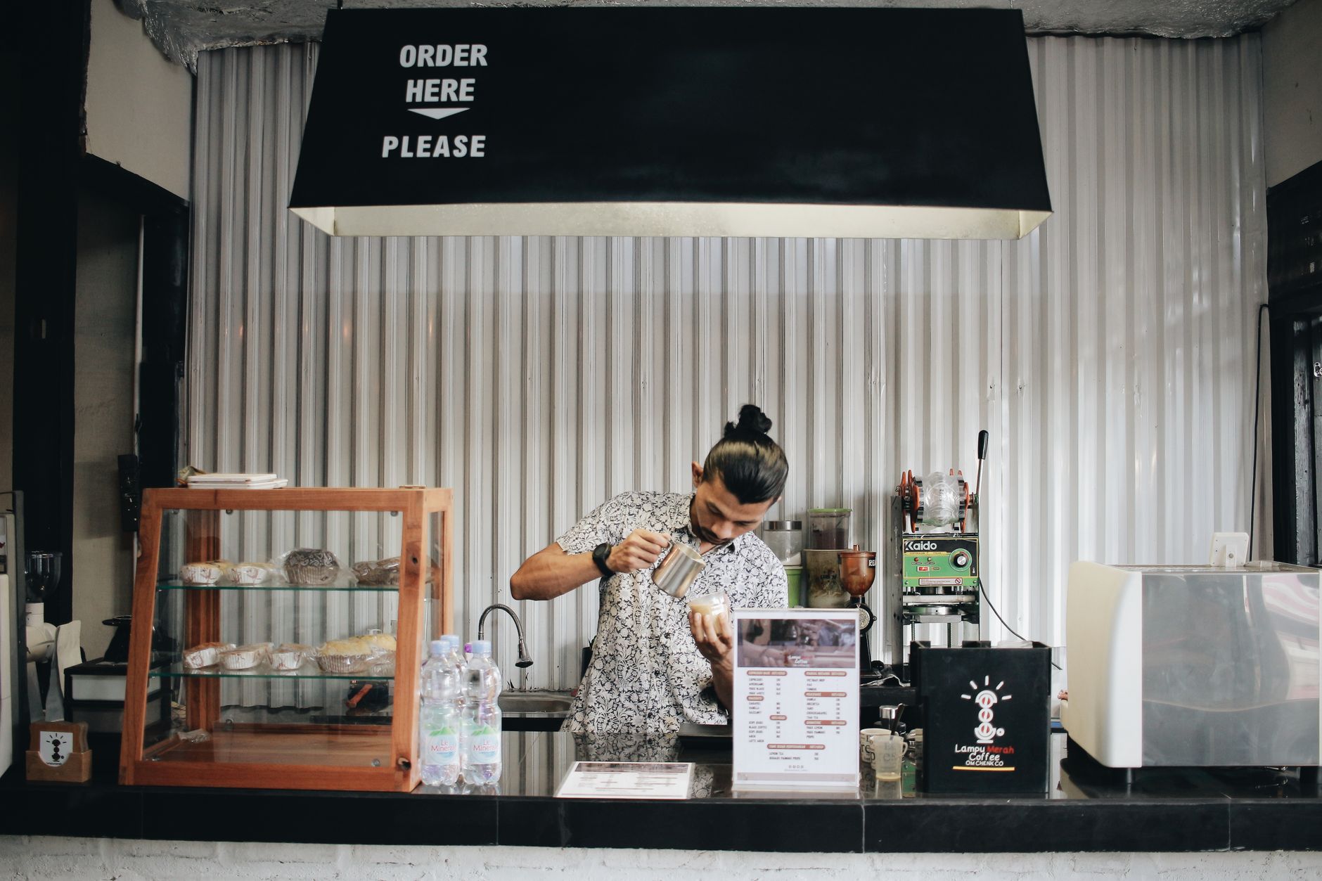 Professional barista operating a high-end espresso machine in a busy cafe