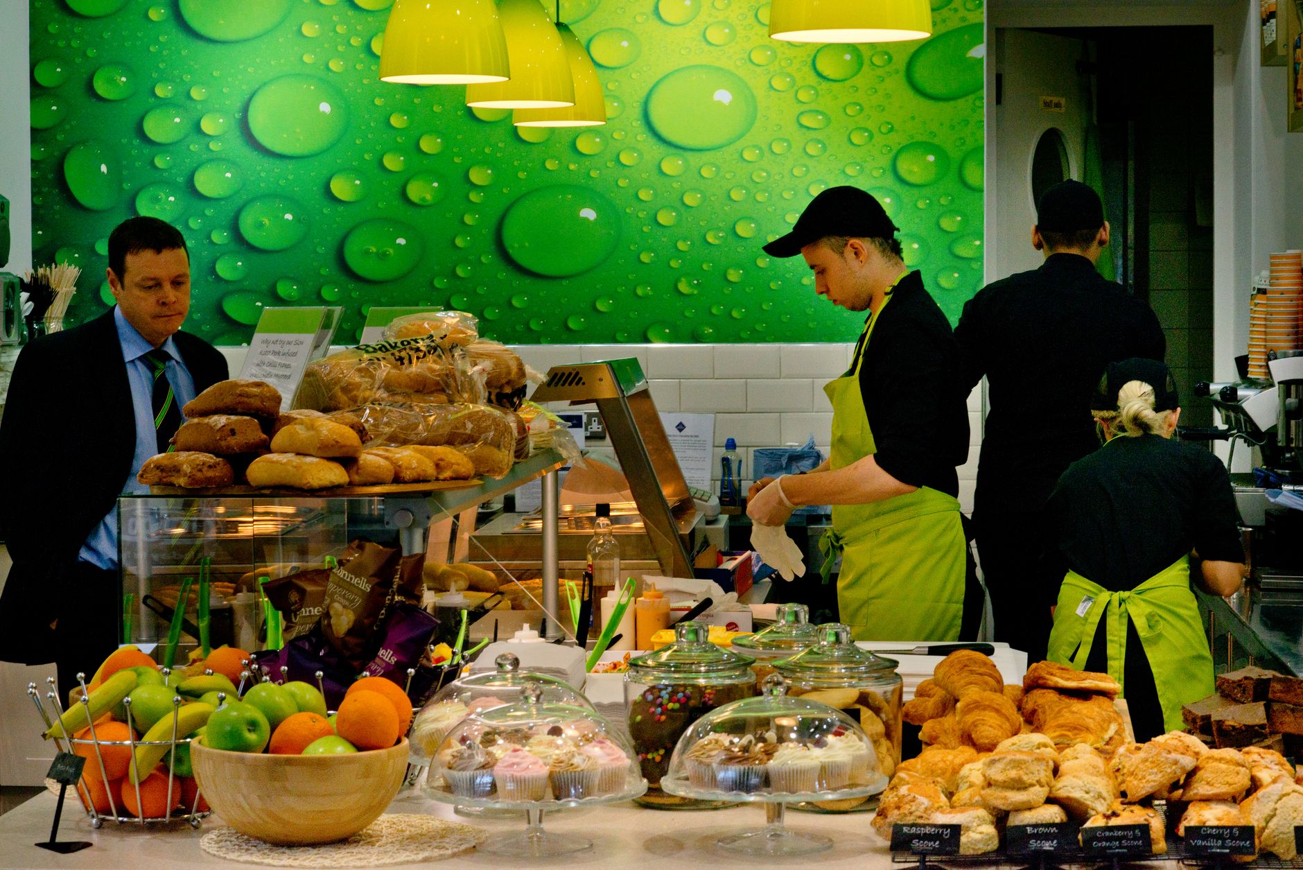Bakery staff serving fresh coffee during morning rush hour