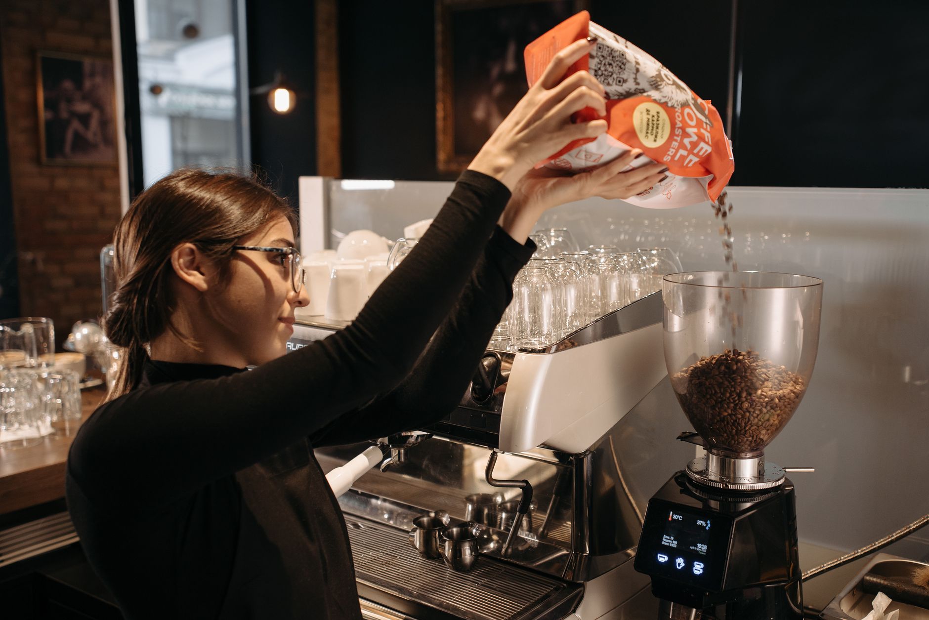 Professional barista serving specialty coffee to executives in corporate setting