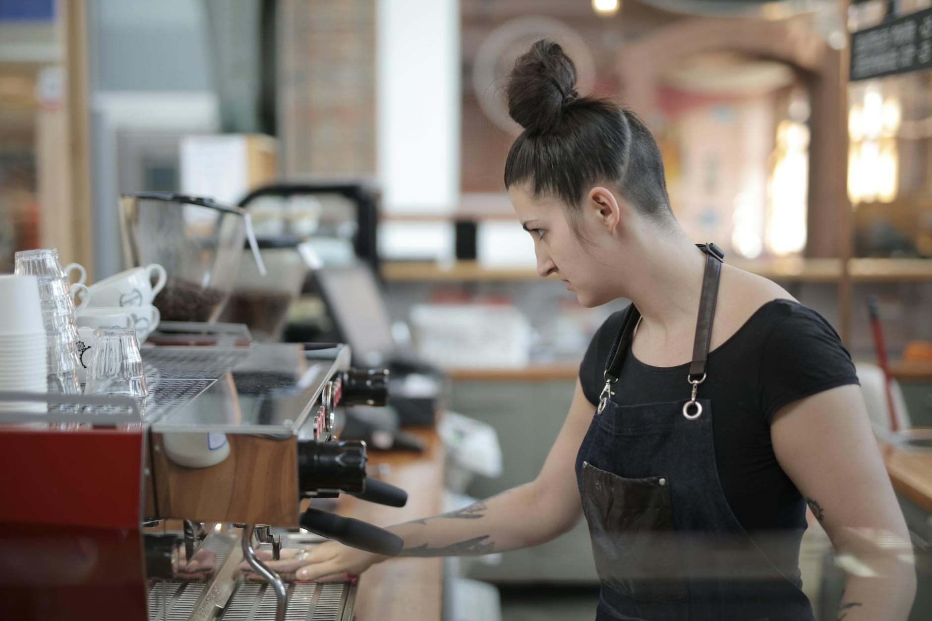 Modern office coffee station with employees brewing drinks