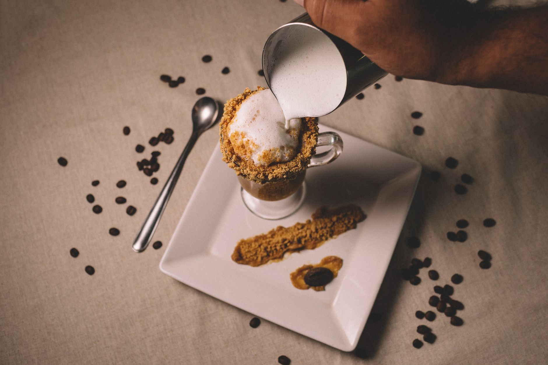 Professional barista pouring intricate latte art design