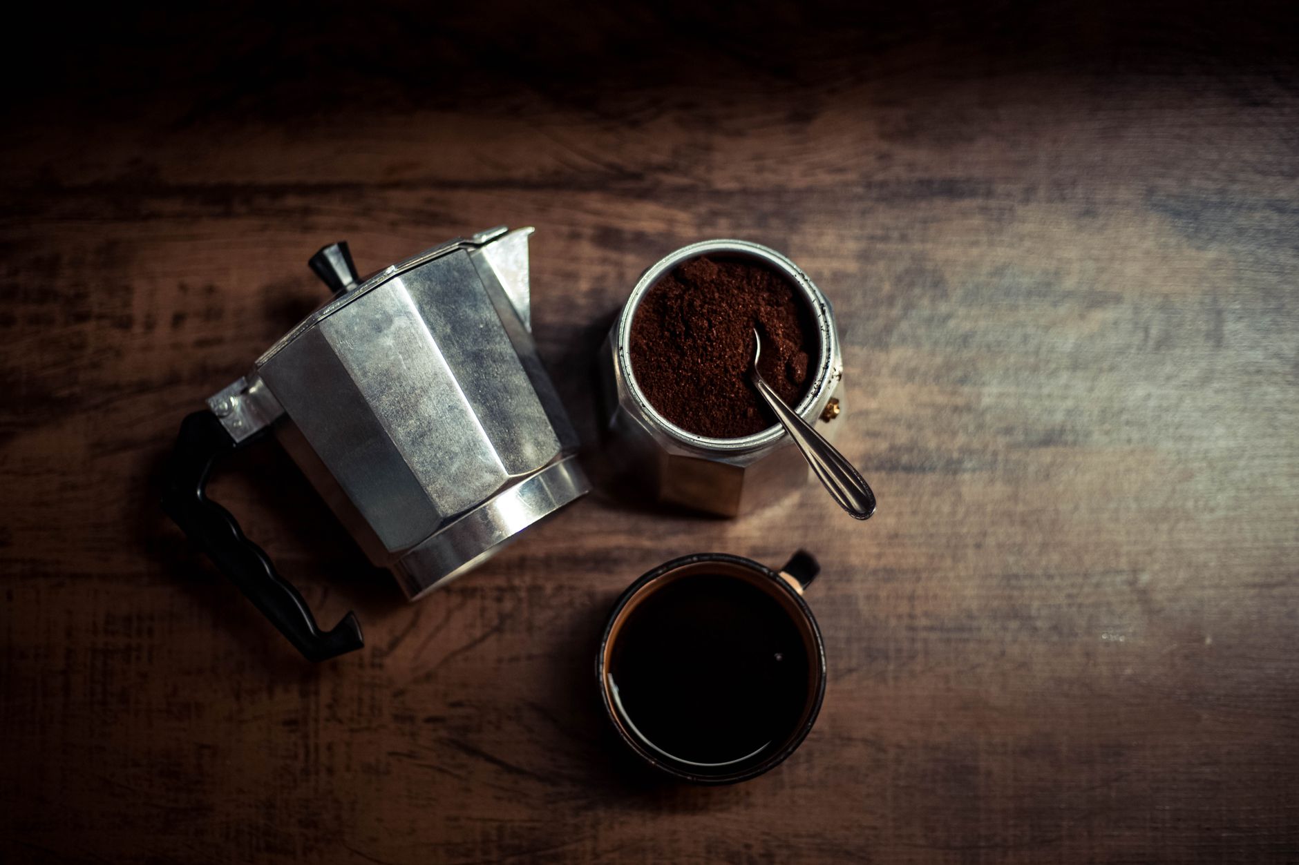 Barista using stainless steel reusable coffee filters in a commercial cafe setting