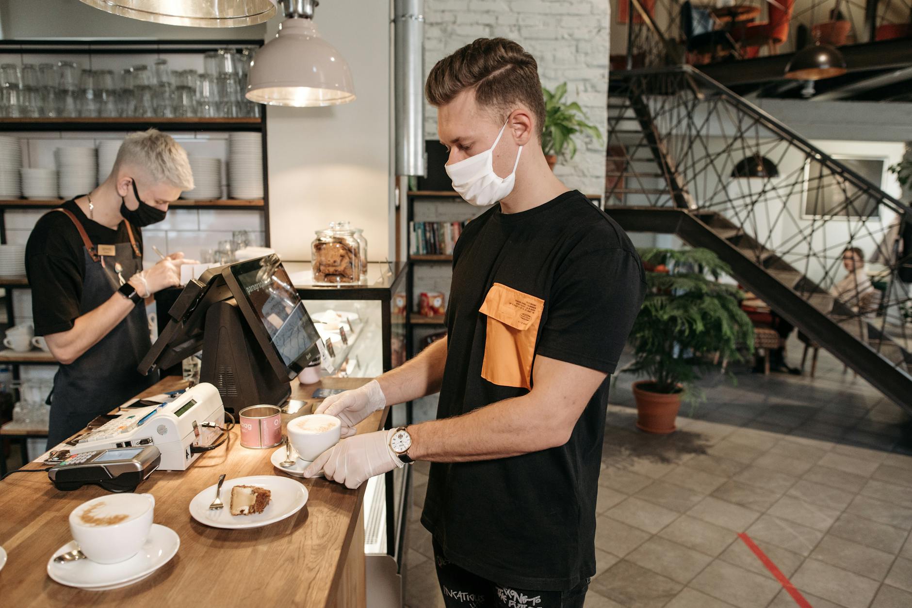 Modern office coffee station with employees pouring drinks