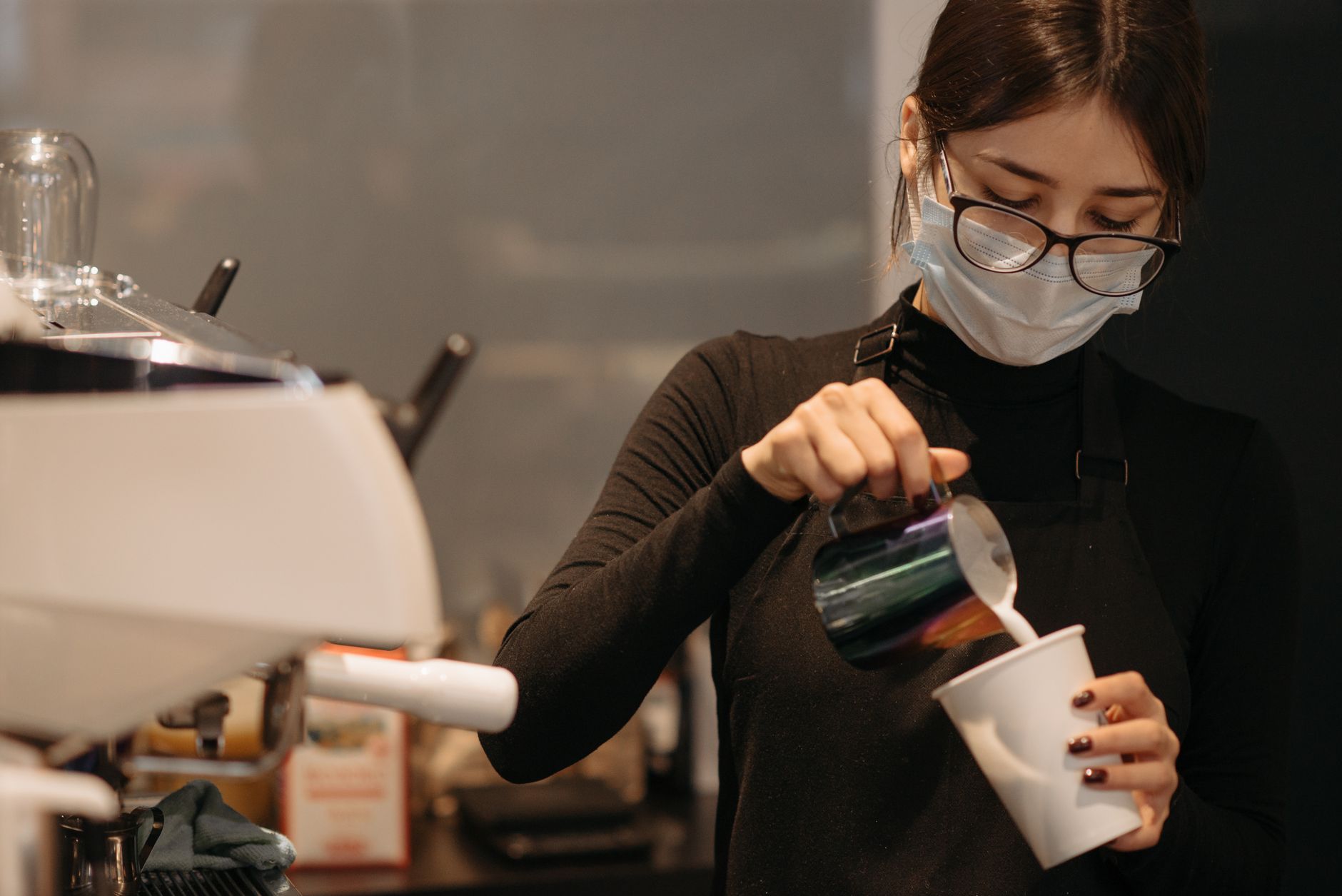 Barista pouring latte art in a busy Los Angeles cafe