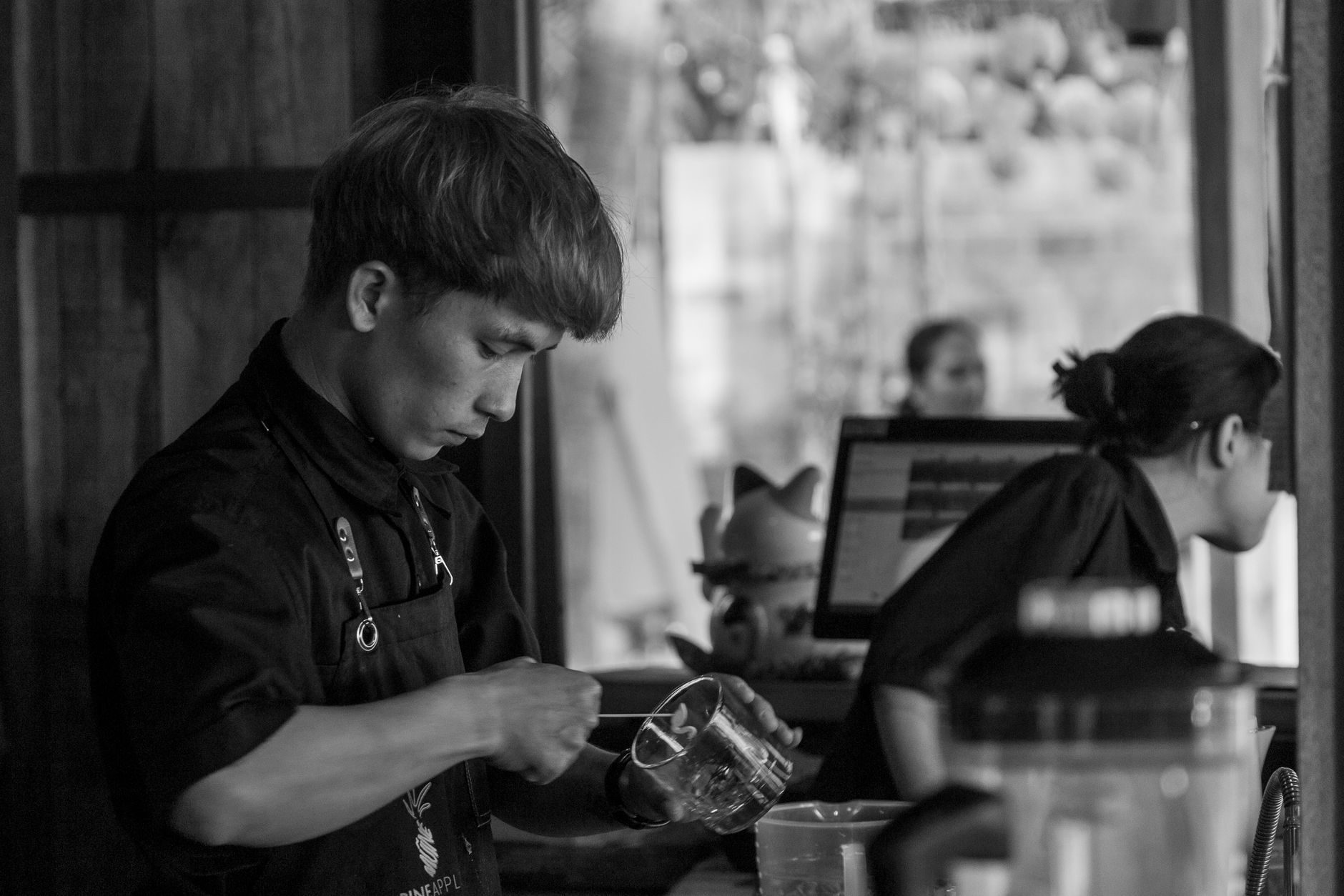 Baristas preparing specialty drinks in a high-volume café setting with modern equipment
