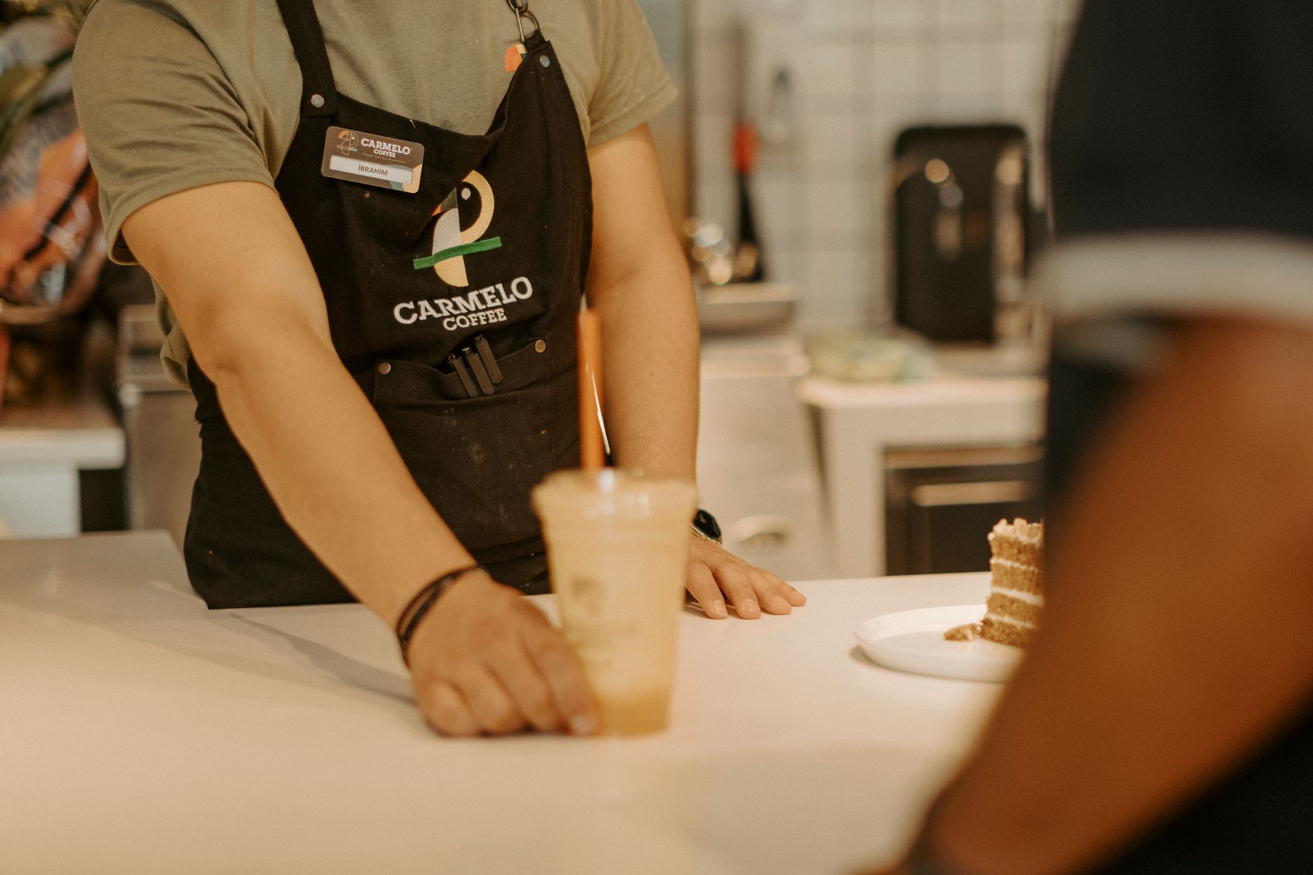 Barista serving specialty coffee in a busy Macon GA cafe with modern espresso machine