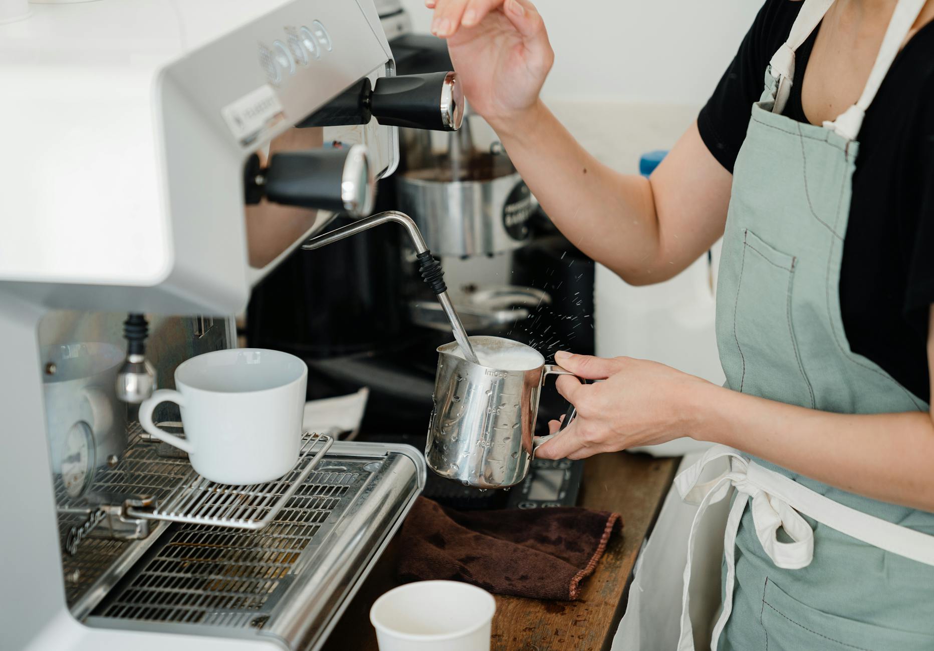 Washington DC law firm employees using a modern espresso machine during a break, with the Capitol building visible through the window