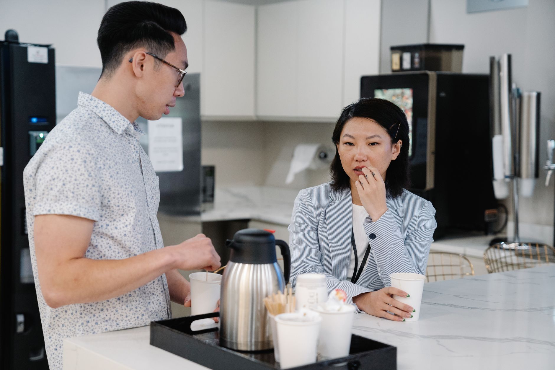 Modern office coffee station bustling with employees enjoying their coffee break.