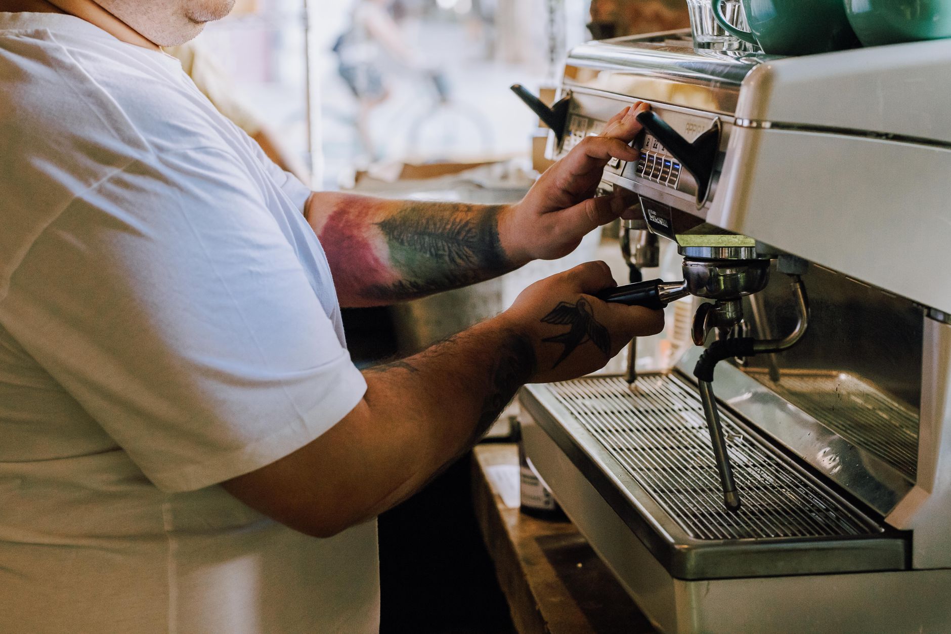 Skilled barista preparing espresso drinks in a busy Mount Pleasant restaurant