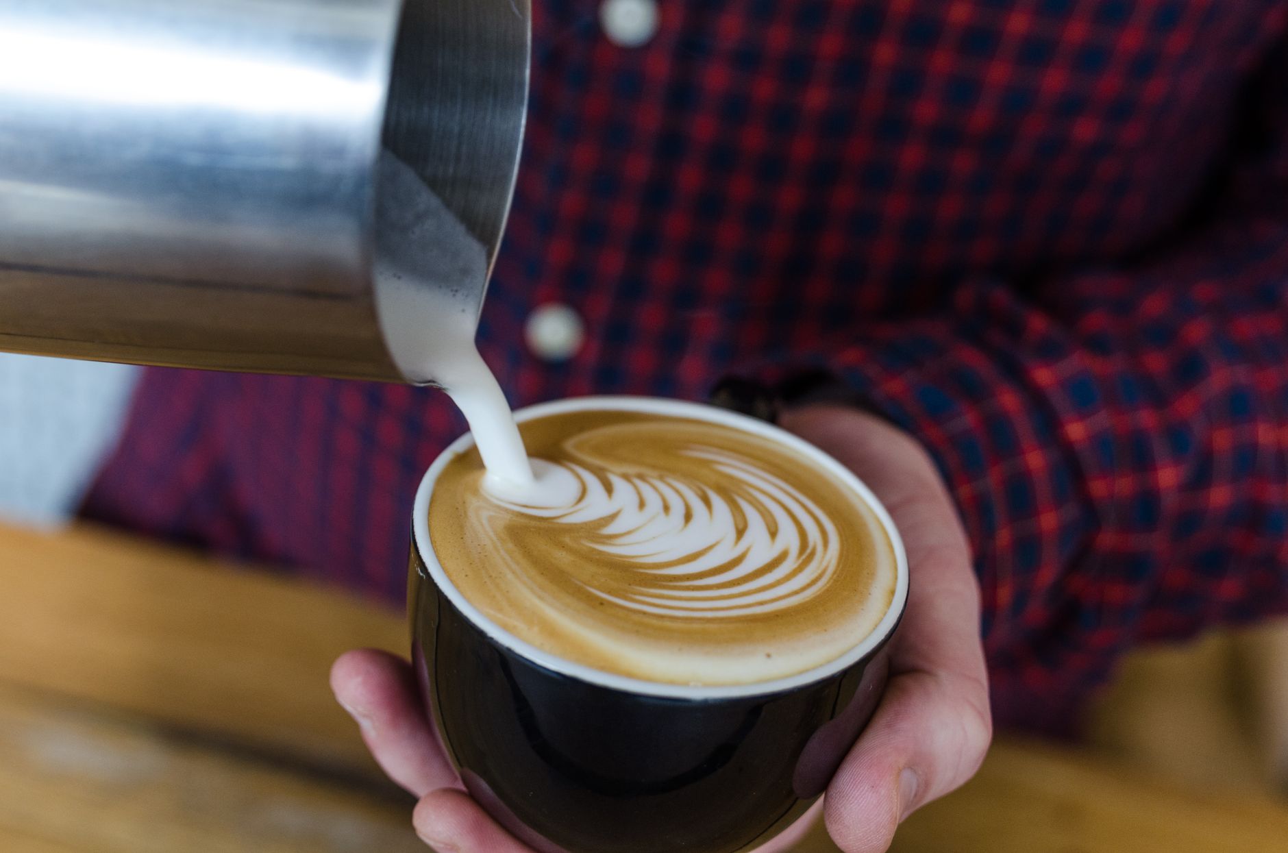 Barista trainer teaching proper milk steaming technique