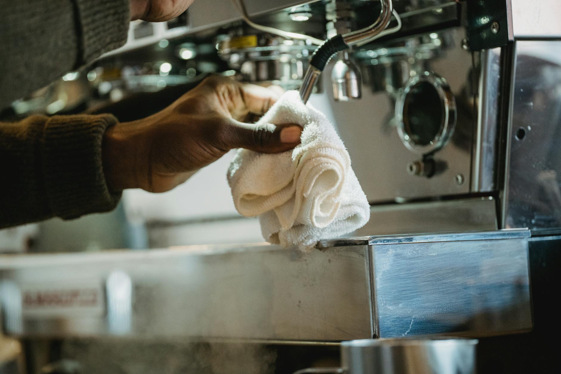 Commercial espresso machine being serviced by a technician in a local coffee shop