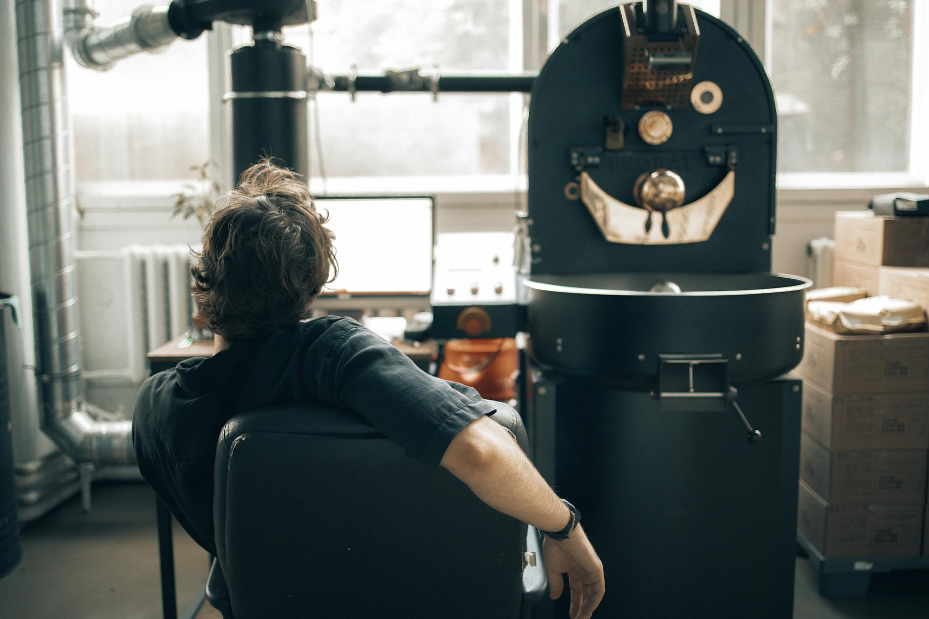 Technician examining large coffee roaster components