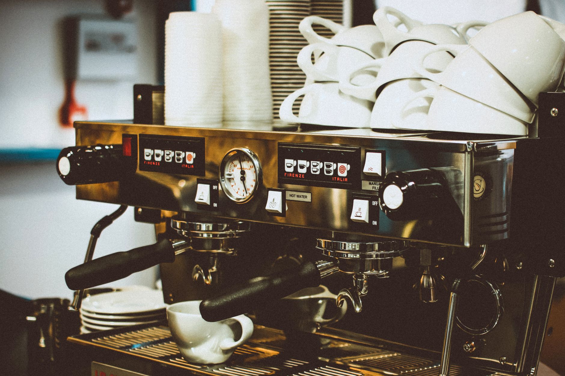 Office breakroom with commercial espresso machine and employees chatting