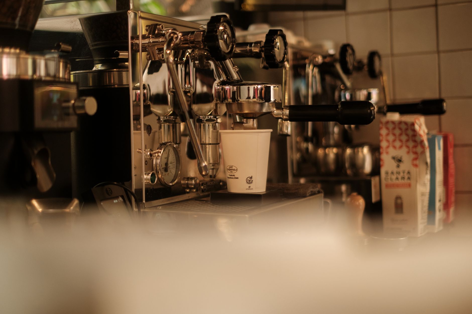 Side-by-side comparison of commercial espresso machines in a cafe setting