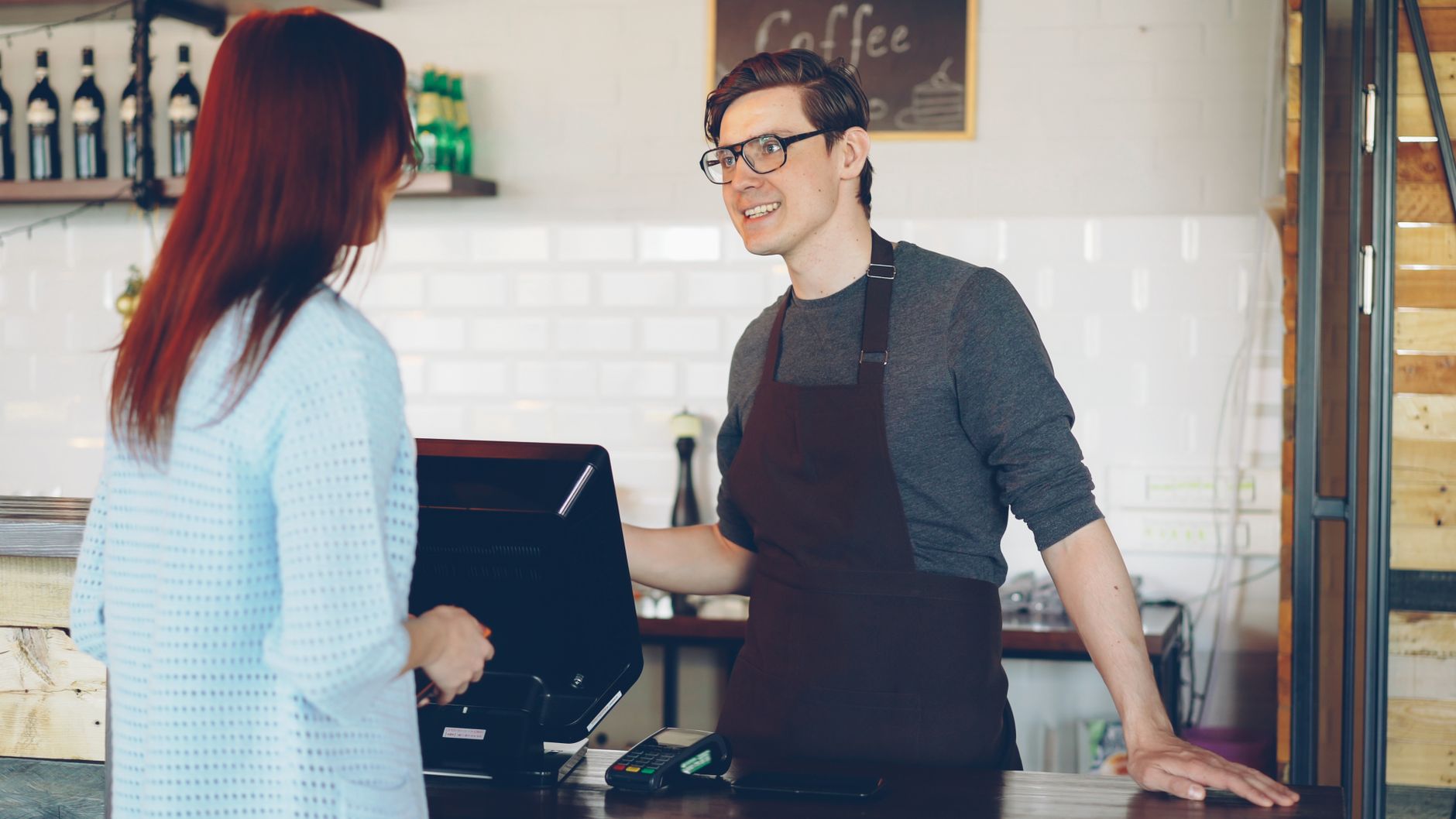 Busy cafe counter showing espresso machine in daily operation