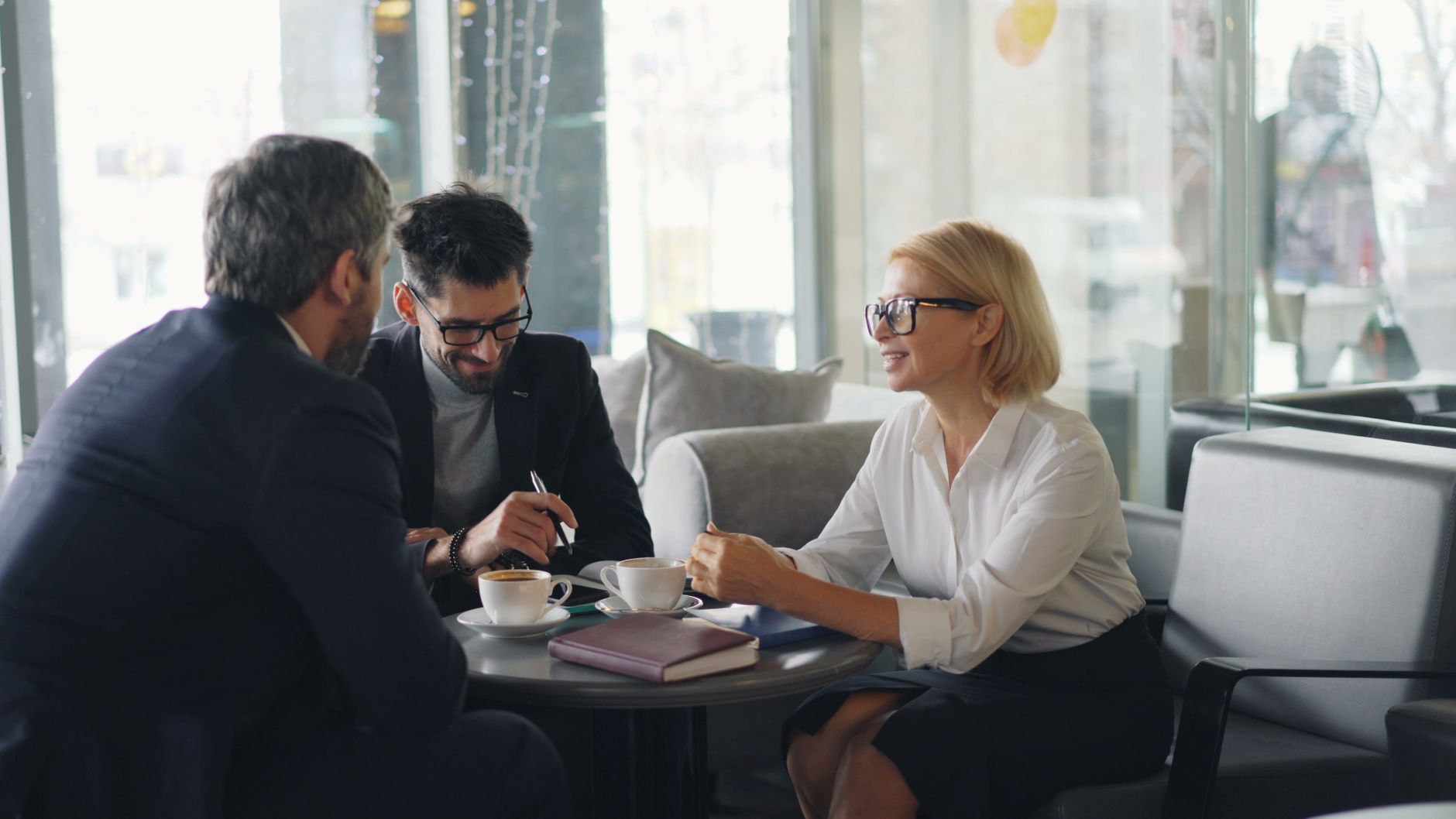 Well-dressed hotel guest smiling while enjoying specialty coffee in elegant lobby