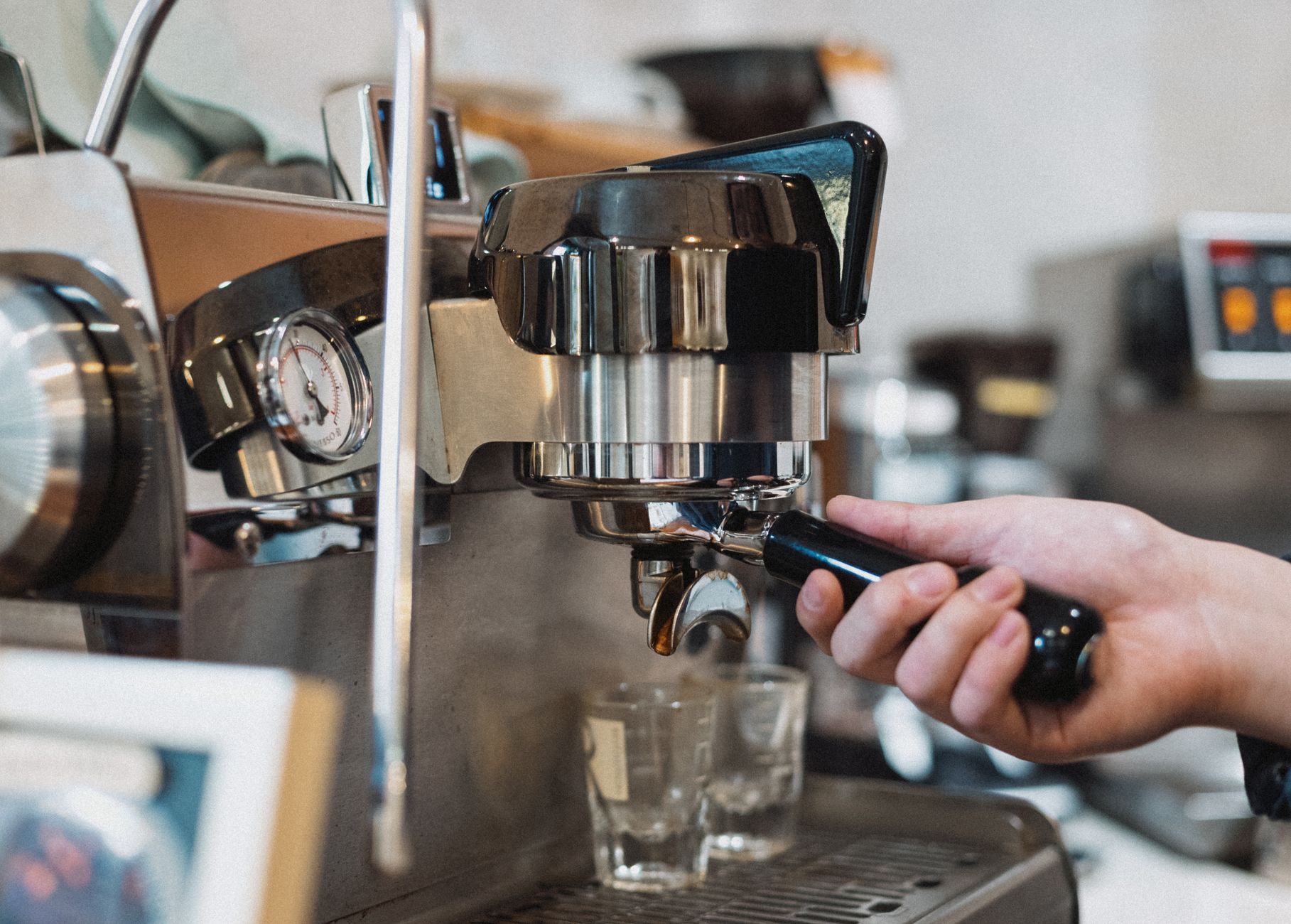 Technician performing maintenance on a commercial espresso machine