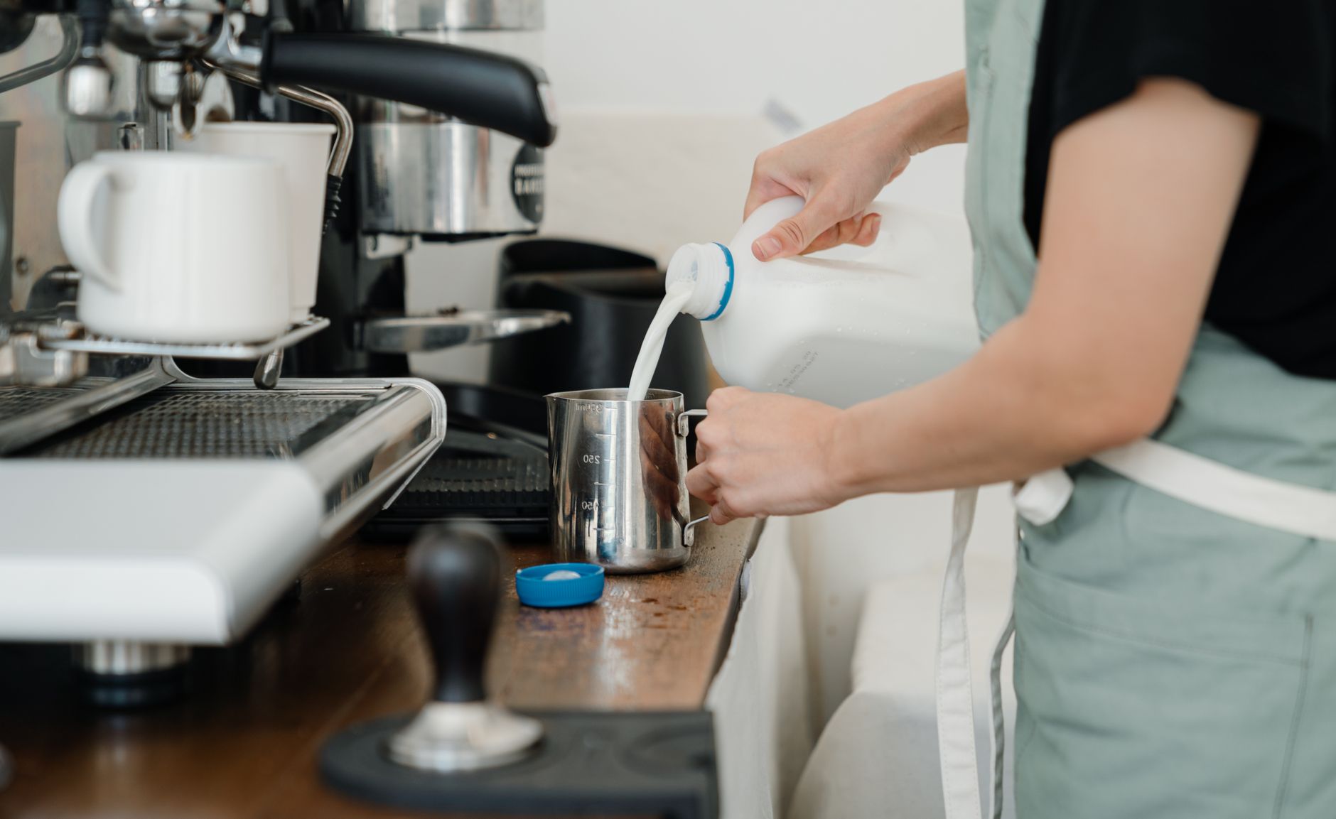 Barista praticando latte art em treinamento