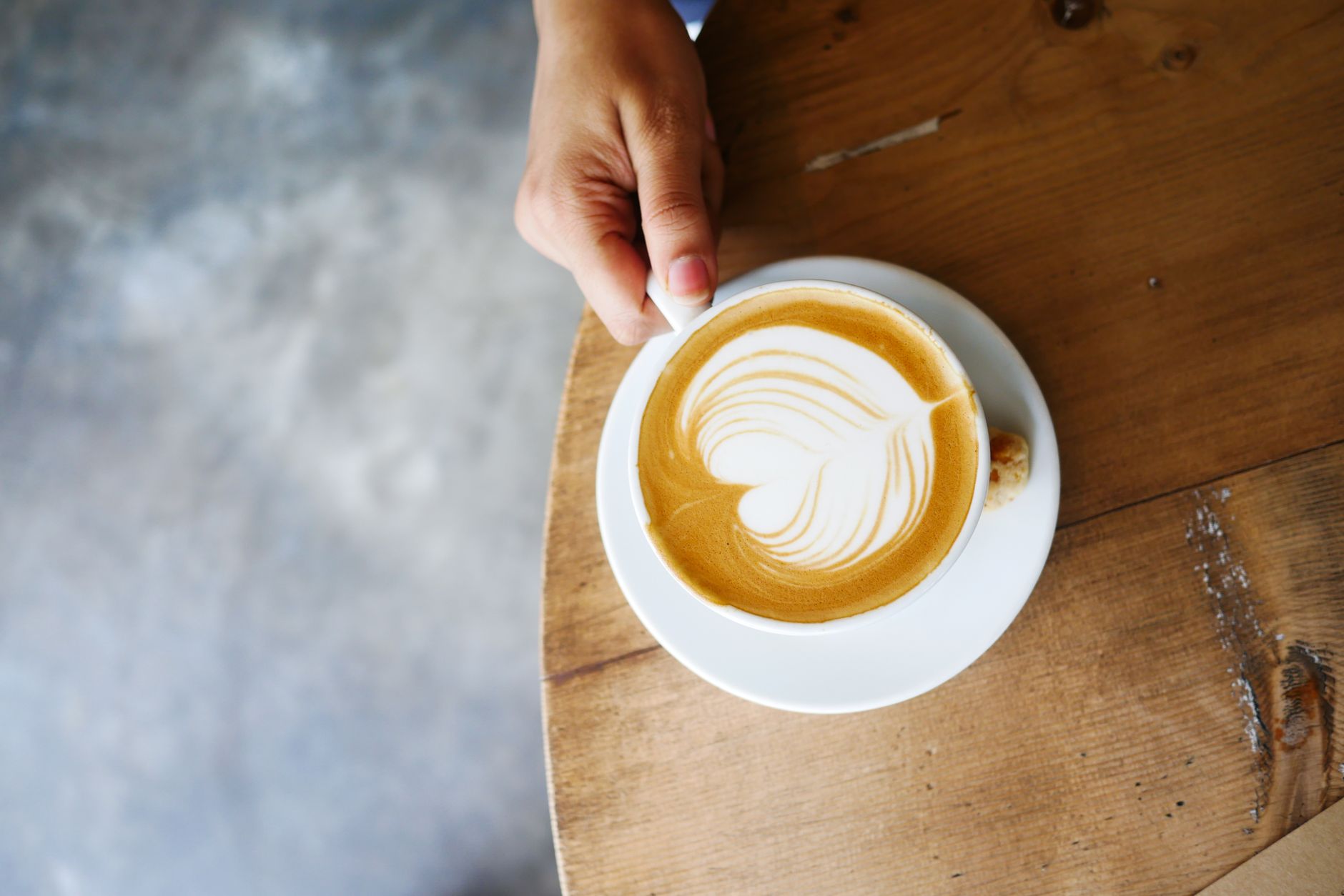 Professional barista creating intricate latte art design