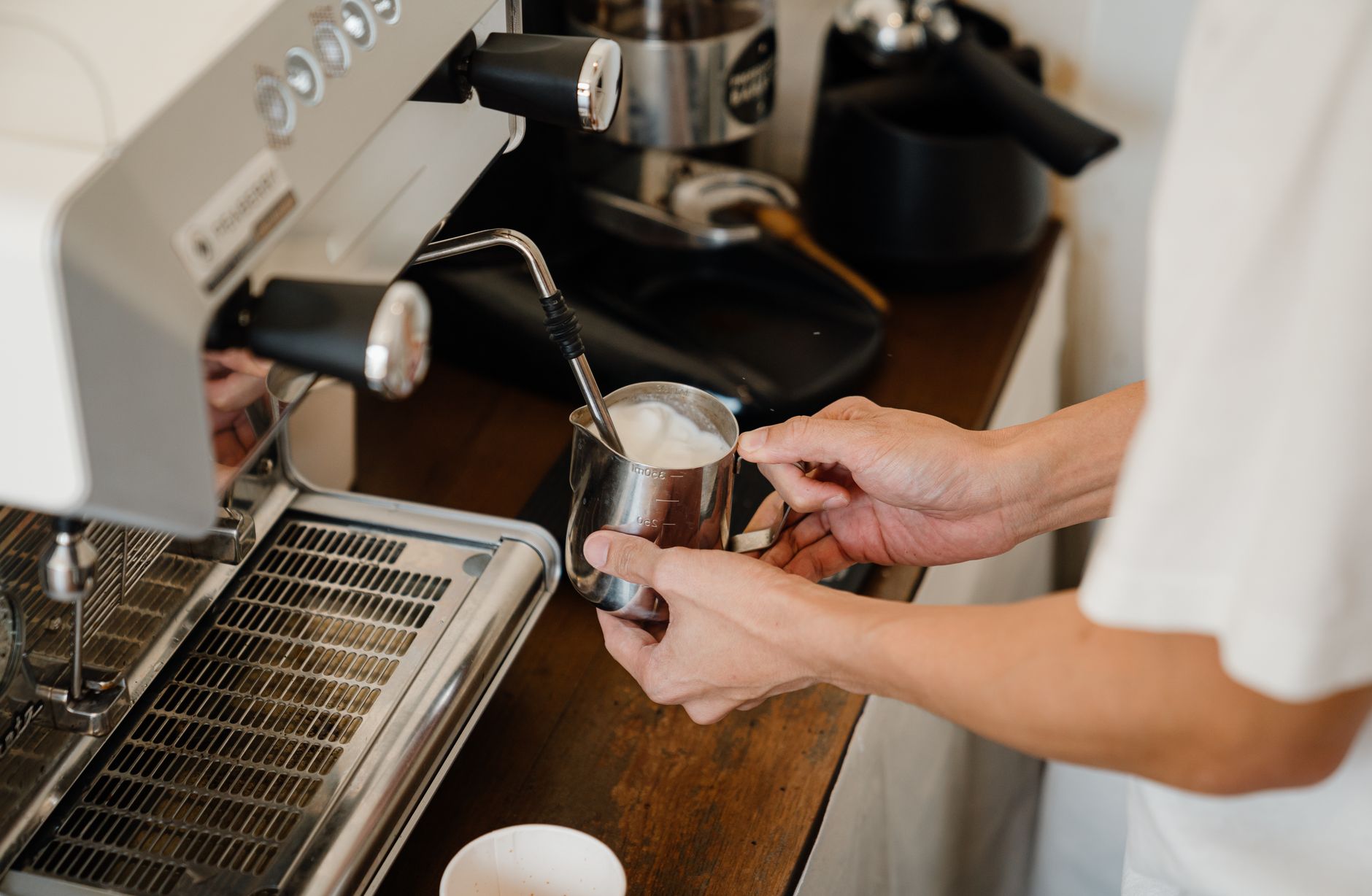 Professional barista crafting specialty coffee drink in commercial setting