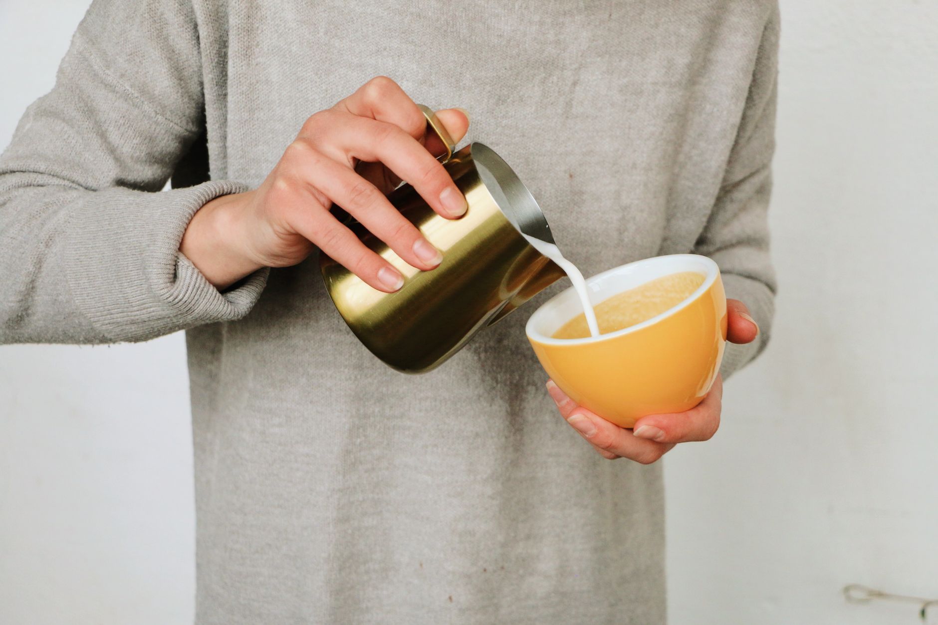 Professional barista manually pouring latte art