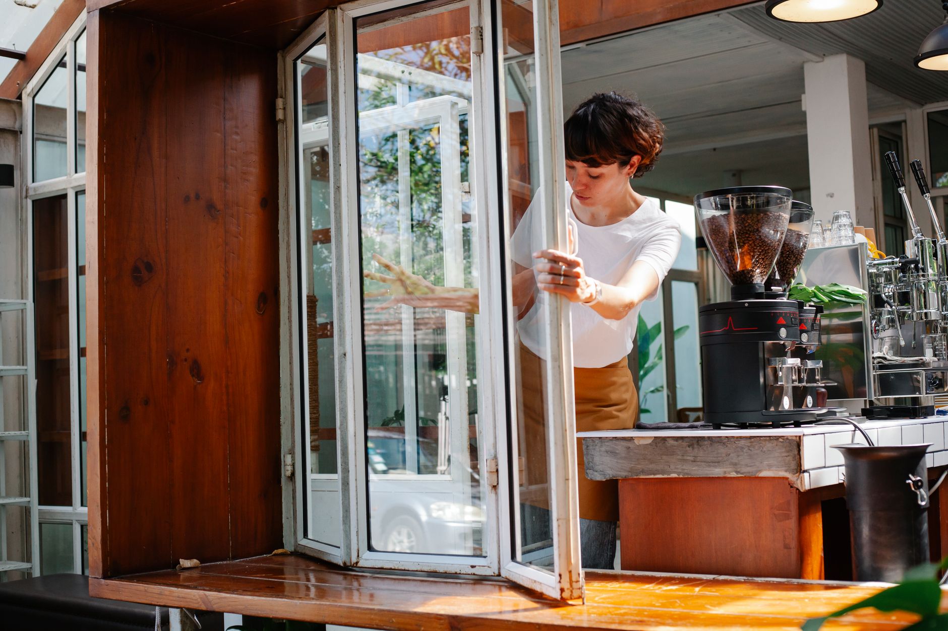 Professional barista preparing french press coffee in modern cafe setting