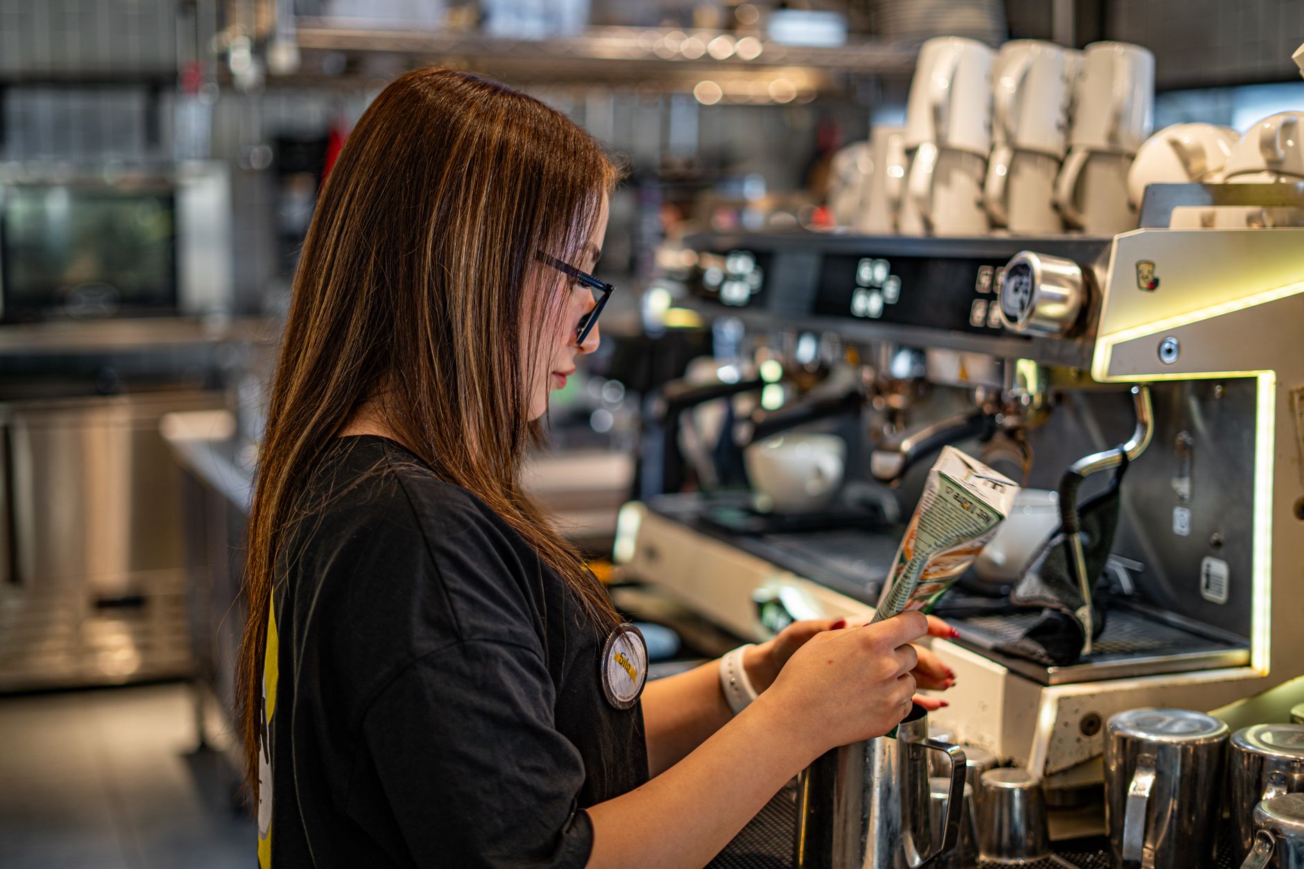 Barista preparing coffee at a busy Miami restaurant counter