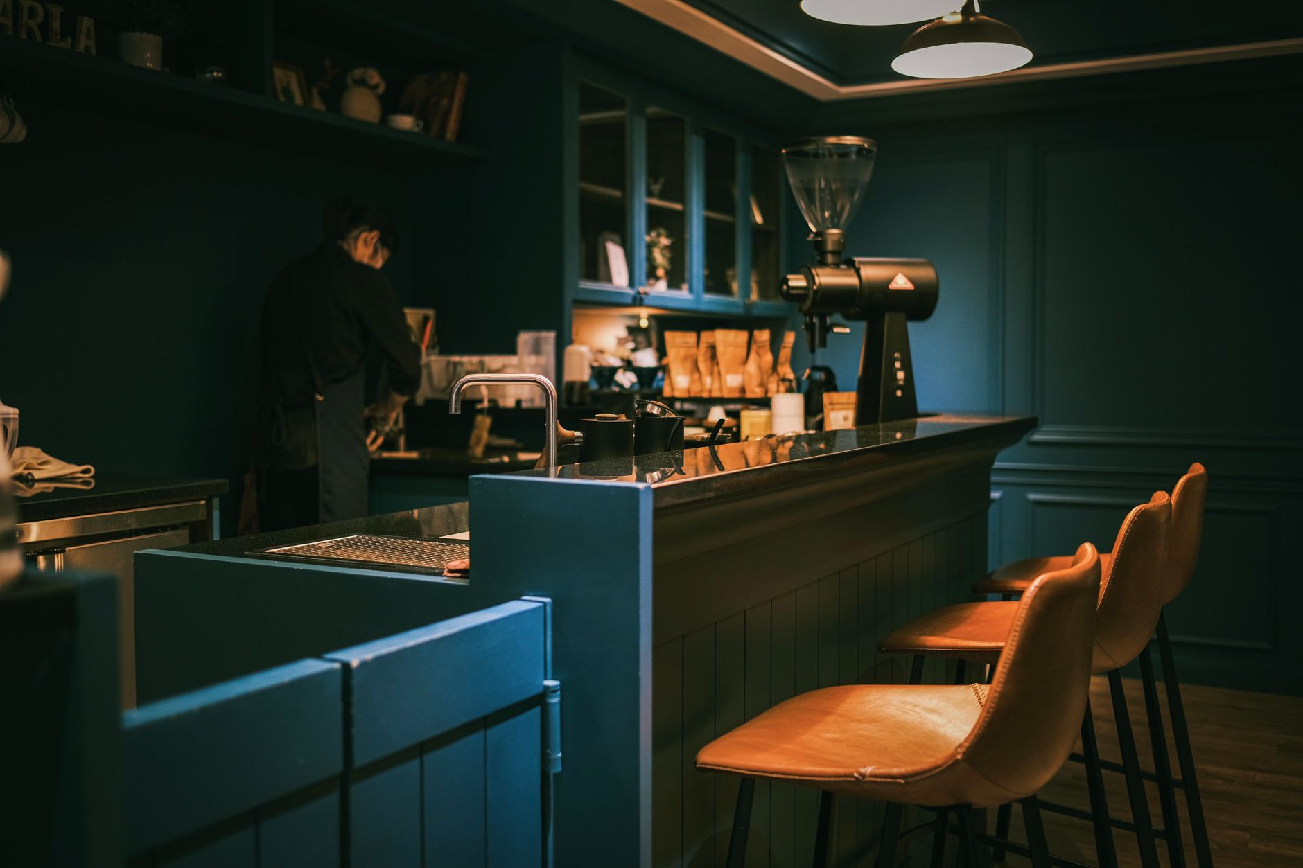 Premium stainless steel barista tools arranged on counter with espresso machine