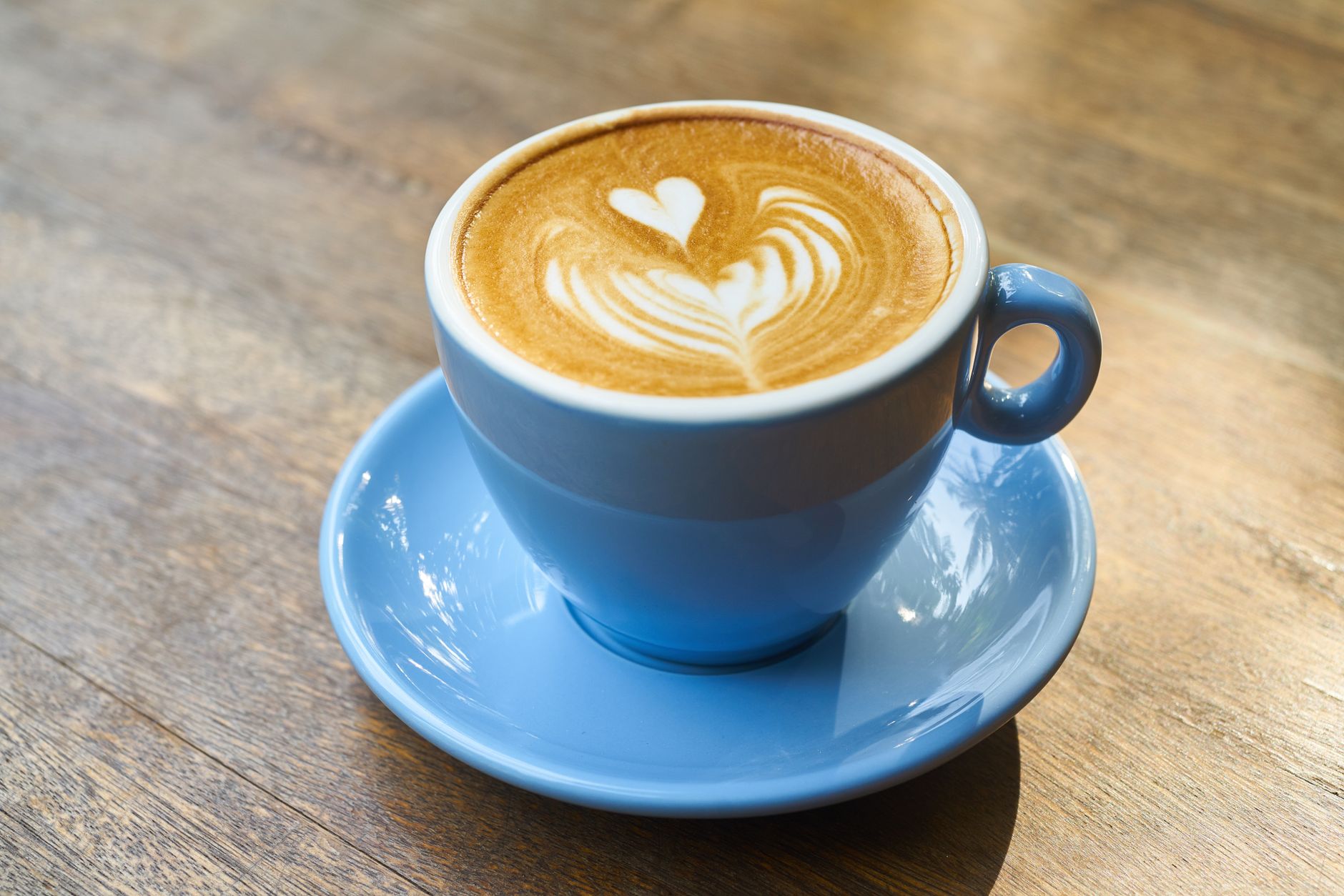 Professional hotel barista creating latte art cappuccino for guest