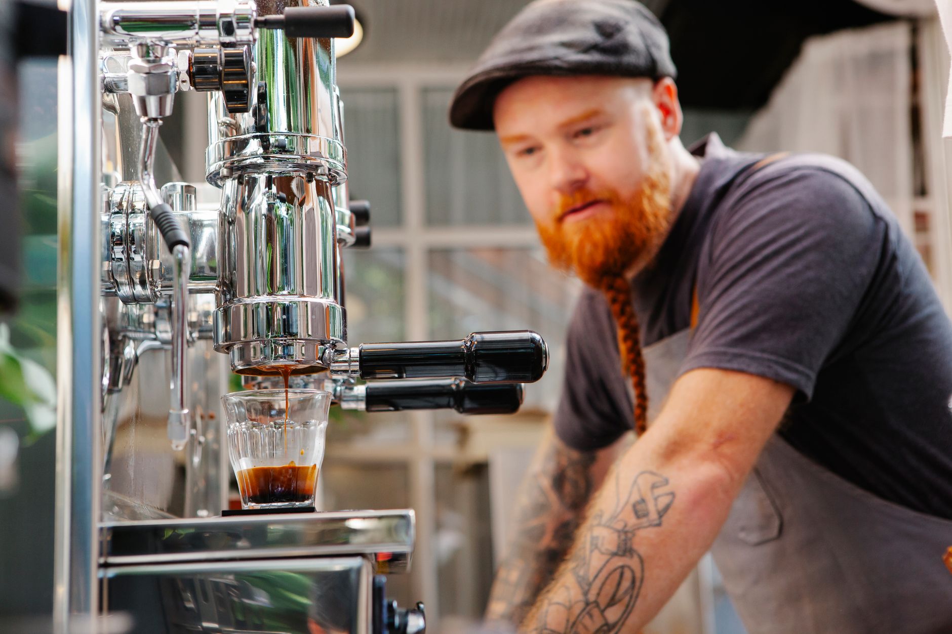 Professional baker preparing espresso drinks alongside pastries