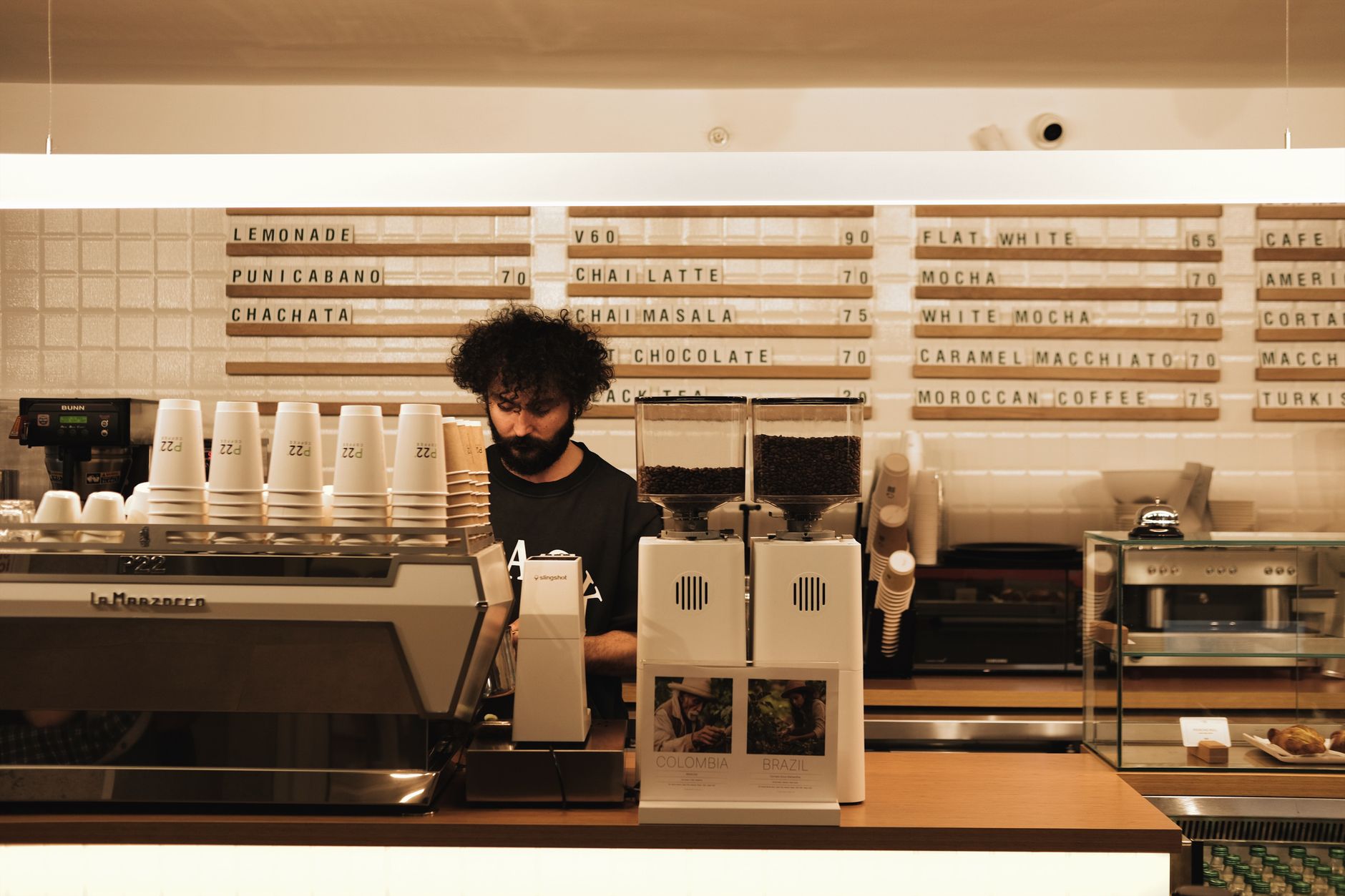 A barista making coffee using a professional espresso machine in a modern café.