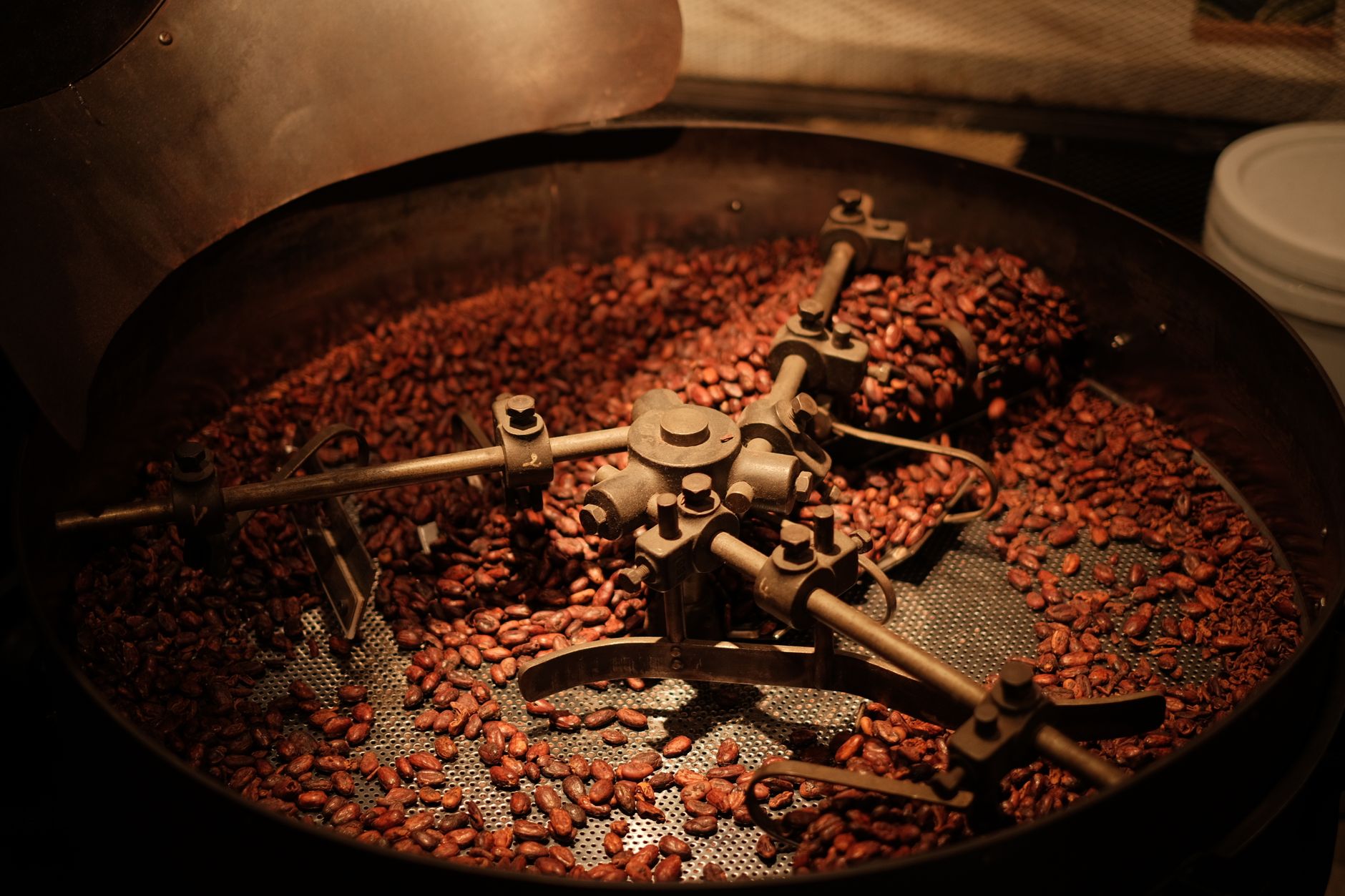 Detailed view of coffee beans roasting in an industrial roaster, showcasing the roasting process.