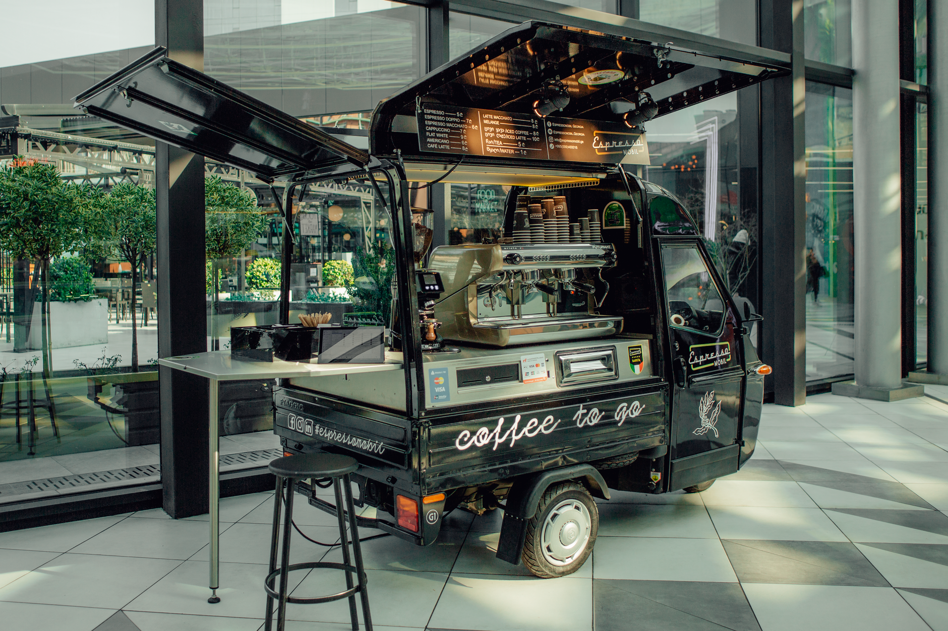 A stylish mobile coffee van serving espresso in a modern urban environment.